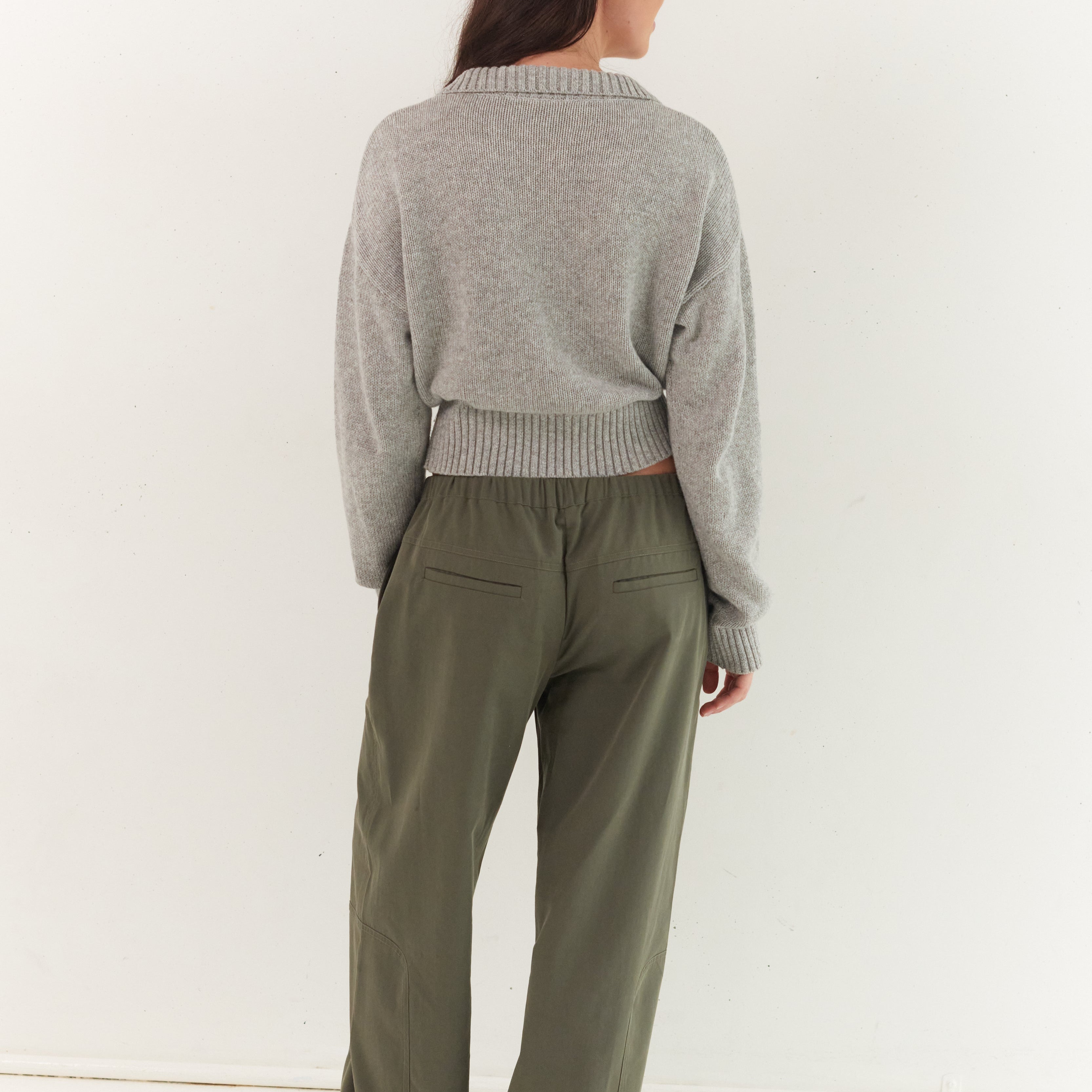 Back view of stone grey Kaia Zip Cardigan showing ribbed collar and cropped silhouette