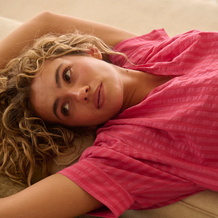 model laying down wearing the Kaitlyn Shirt Raspberry pink Stripe by Kireina