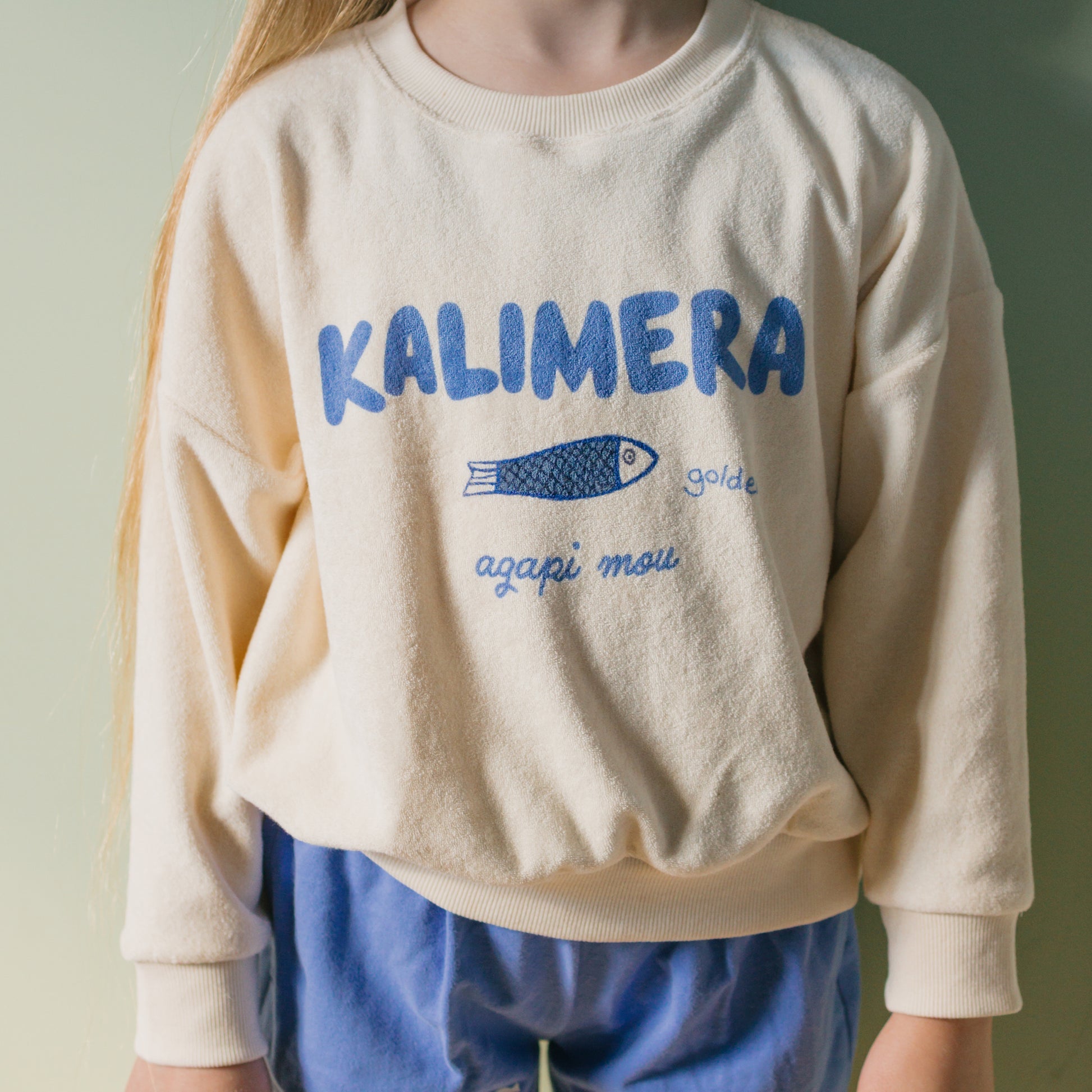 Front view of child in the blue and beige Kalimera Sweater - Buttercream | Golden Children