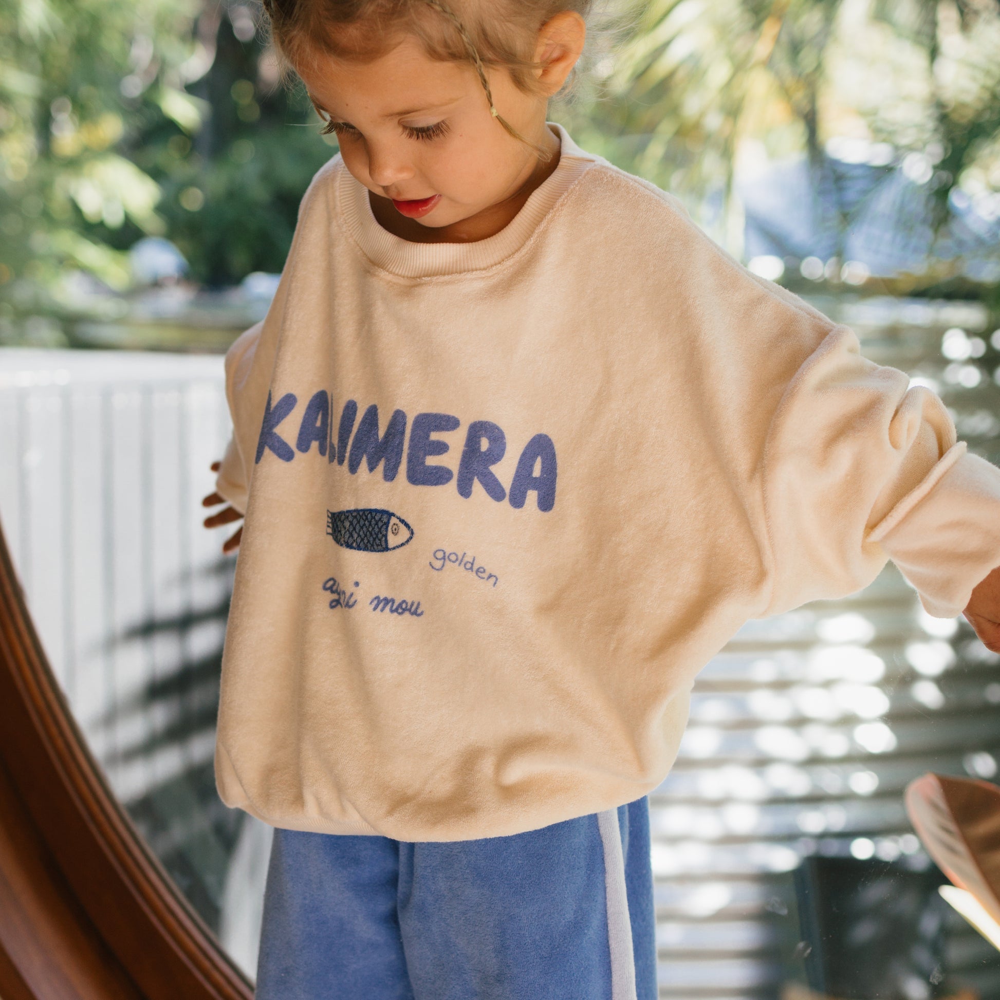 Side angle of kid wearing the Kalimera Sweater - Buttercream | Golden Children