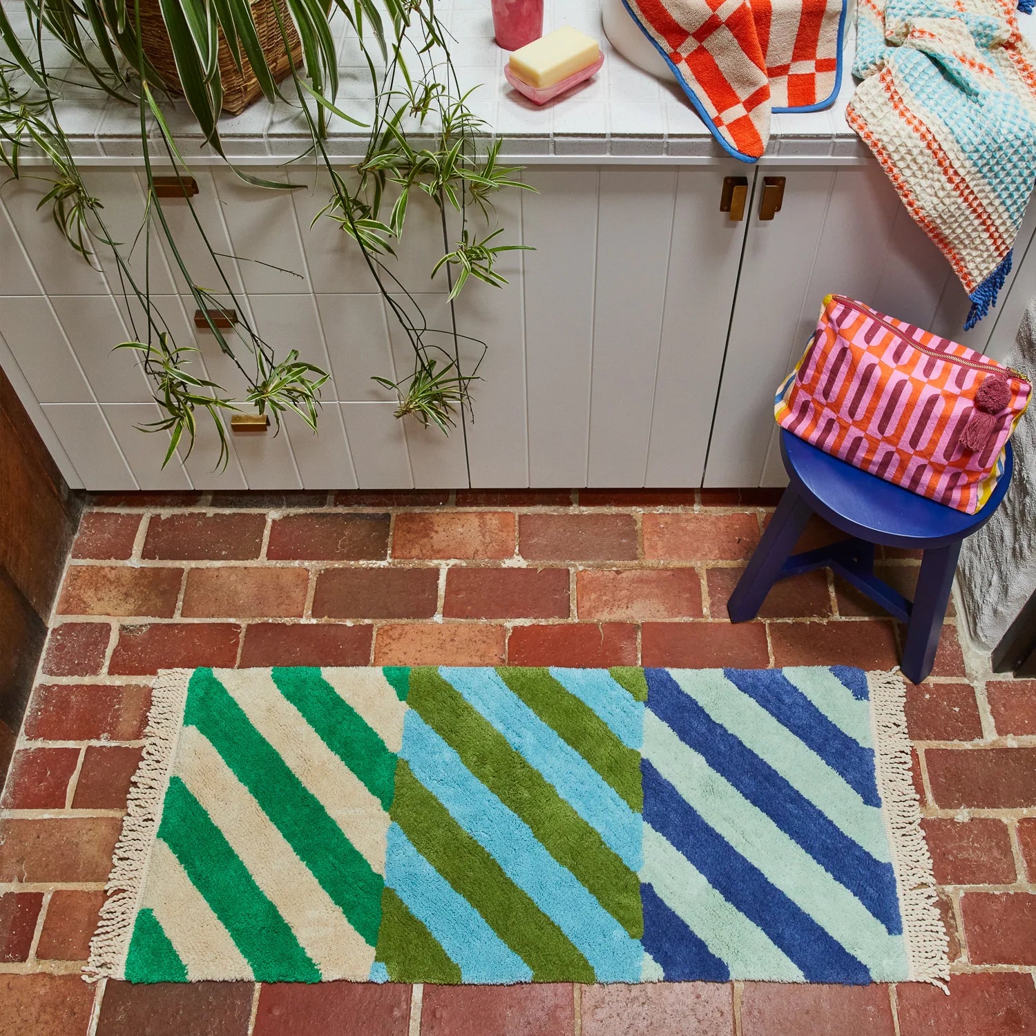 Bathroom lifestyle shot of blue and green bath runner from sage and Clare