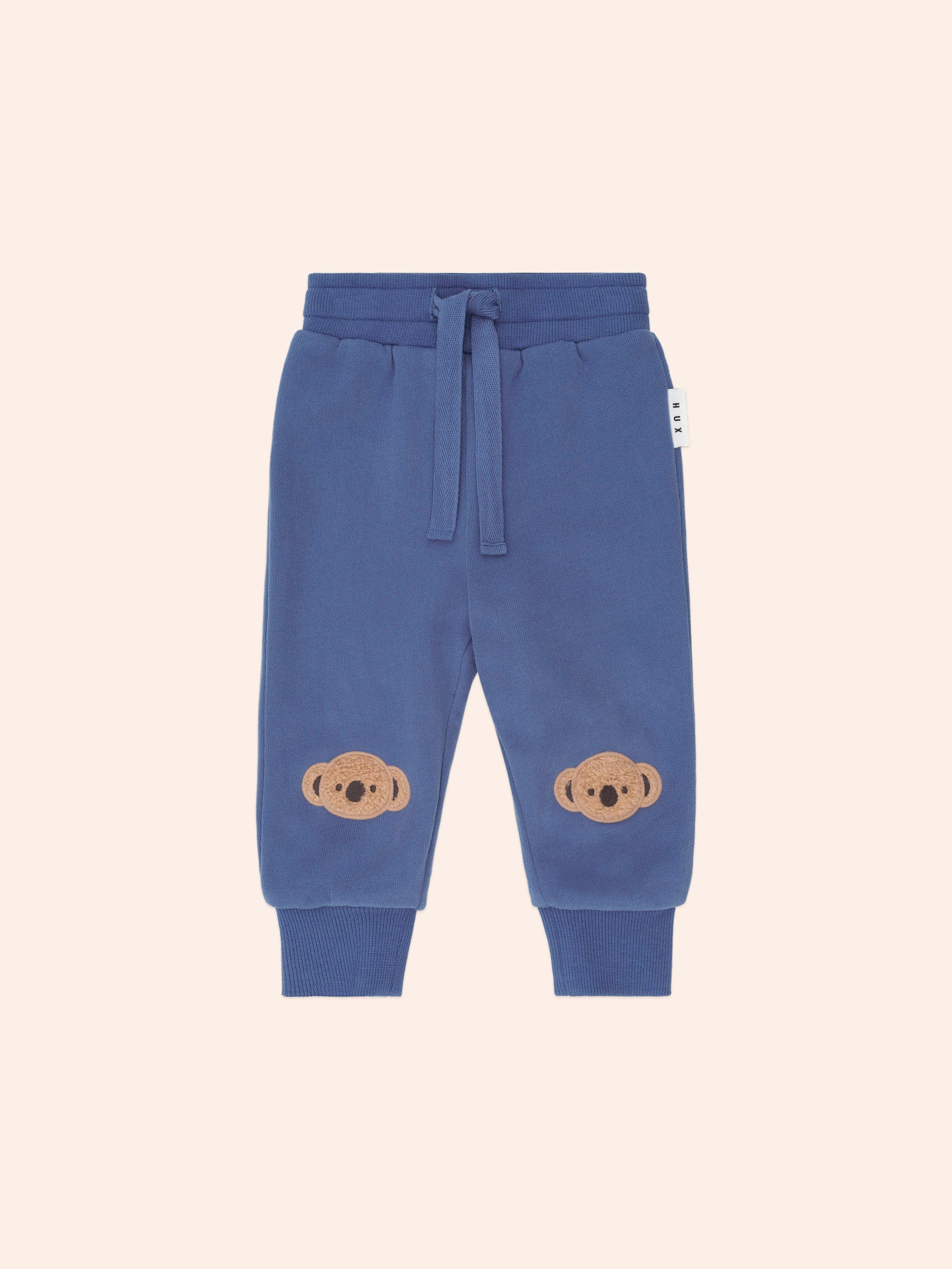 Front view of Huxbaby Kel Koala Trackpant in blue with koala appliques on knees and drawstring waist