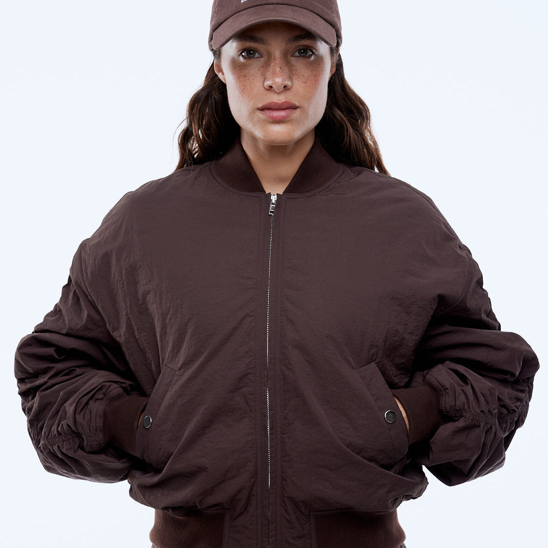 Model wearing Ena Pelly Lulu Bomber mocha puffer jacket lifestyle outdoor urban setting