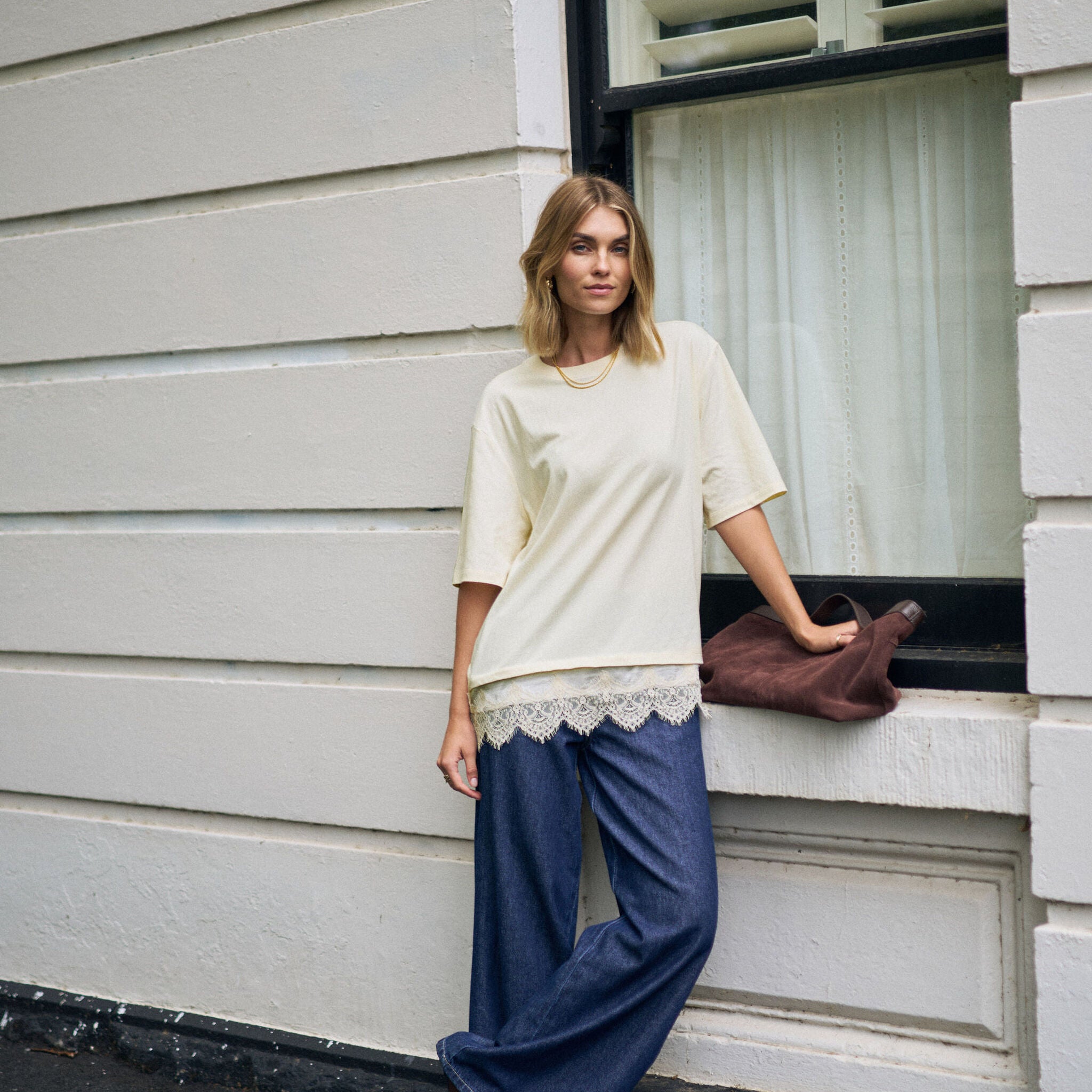 Full body styling of Lacey Tee in marshmallow cream paired with wide leg jeans
