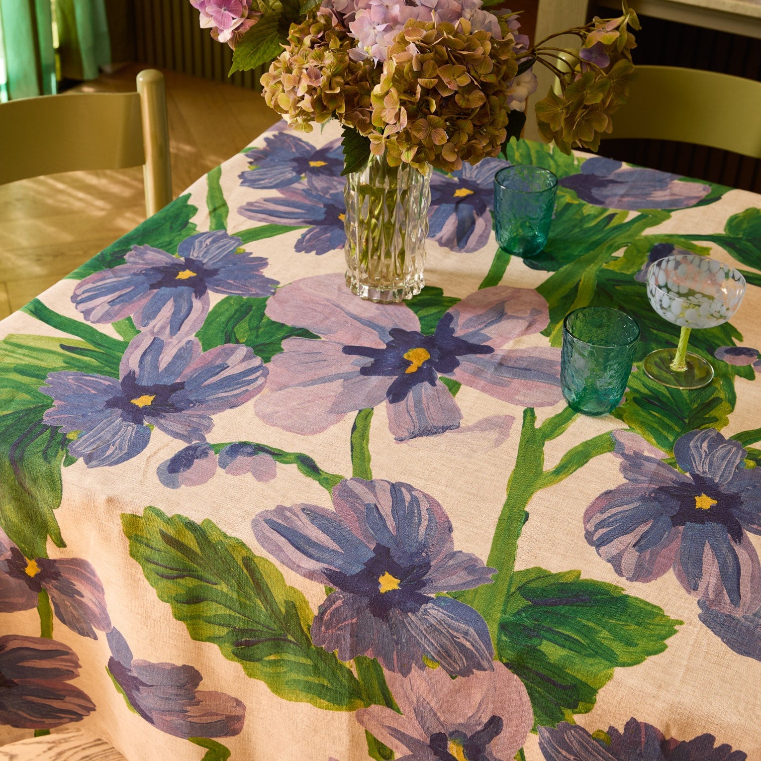 Close-up view of Lilas Blue Tablecloth showing detailed purple flowers and green leaves pattern on linen fabric
