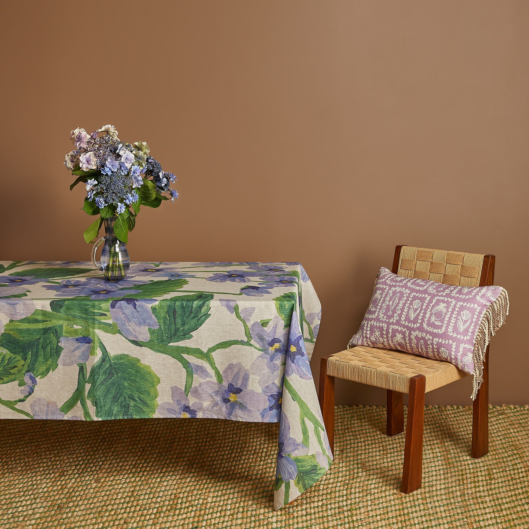 Side view of Lilas Blue Tablecloth on table showing natural fabric fall and purple botanical print