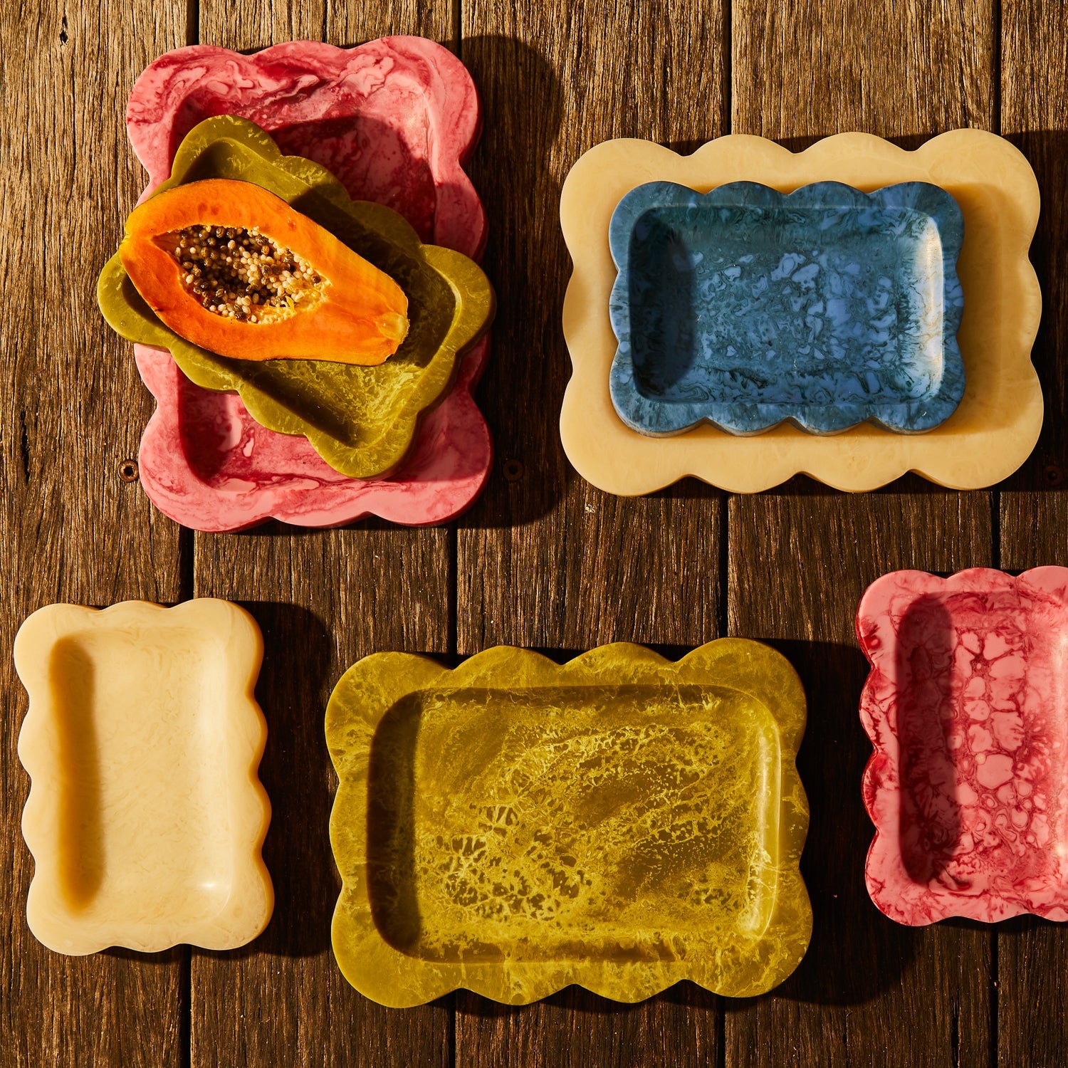 Pearl scalloped resin small tray nested with blue tray, styled with colorful trays and fruit on rustic wood surface