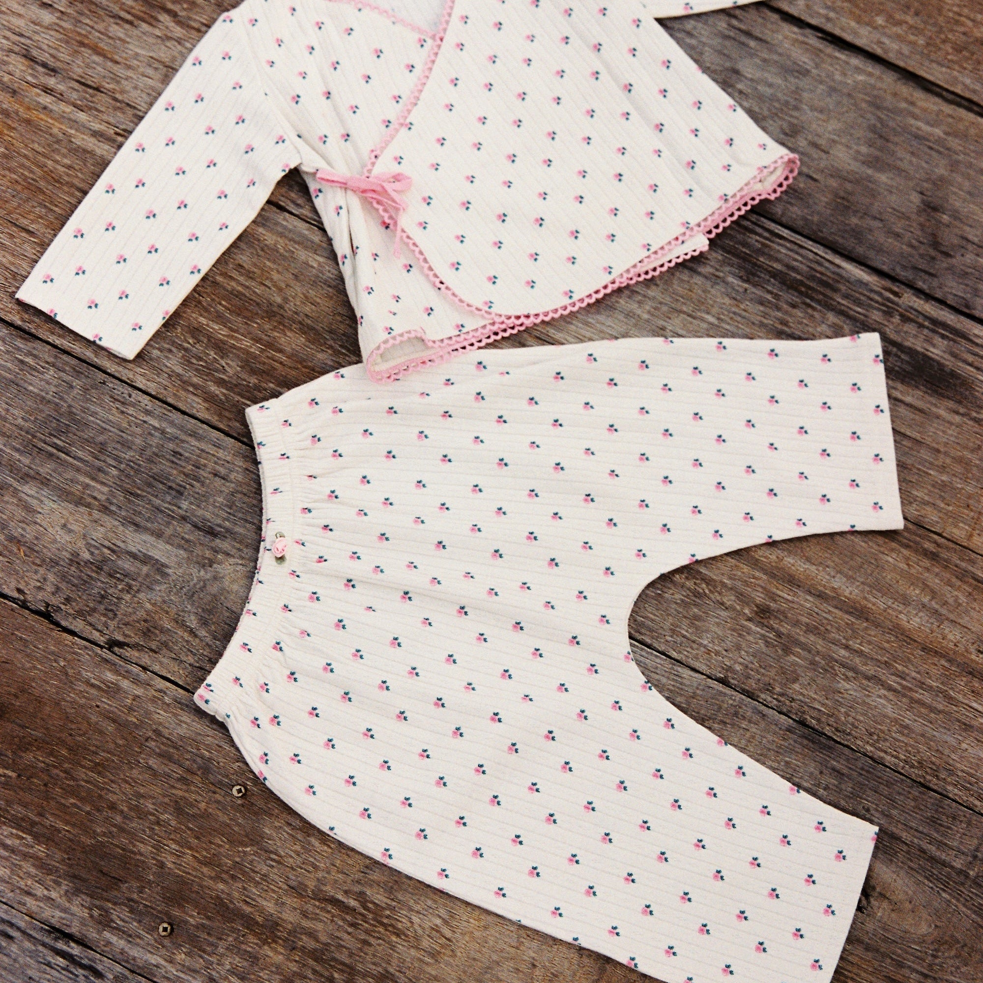 Flat lay of Lolly Set pajama pieces showing roses pattern and pink trim detailing