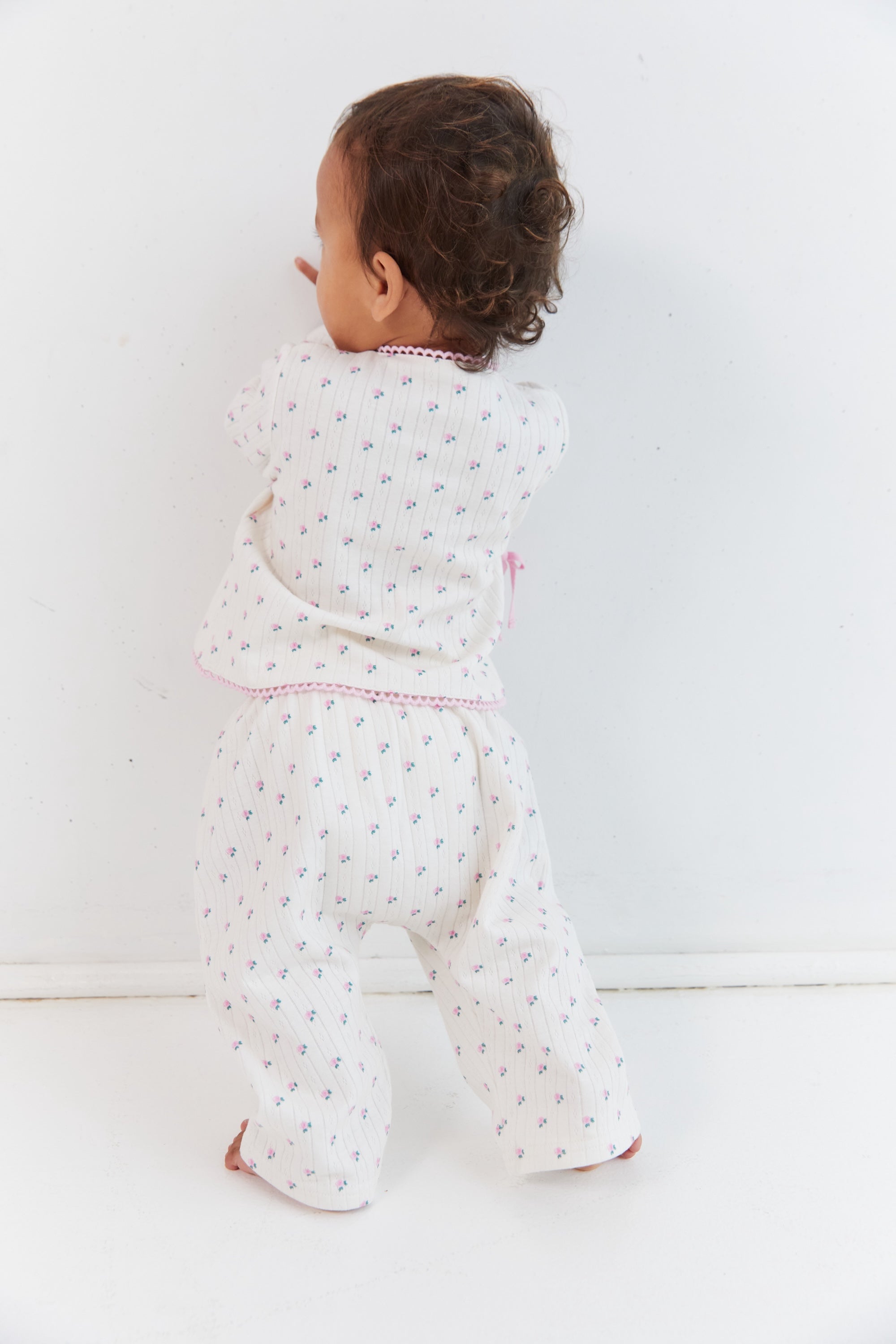 Back view of child wearing complete Lolly Set showing roses pattern and pink trim