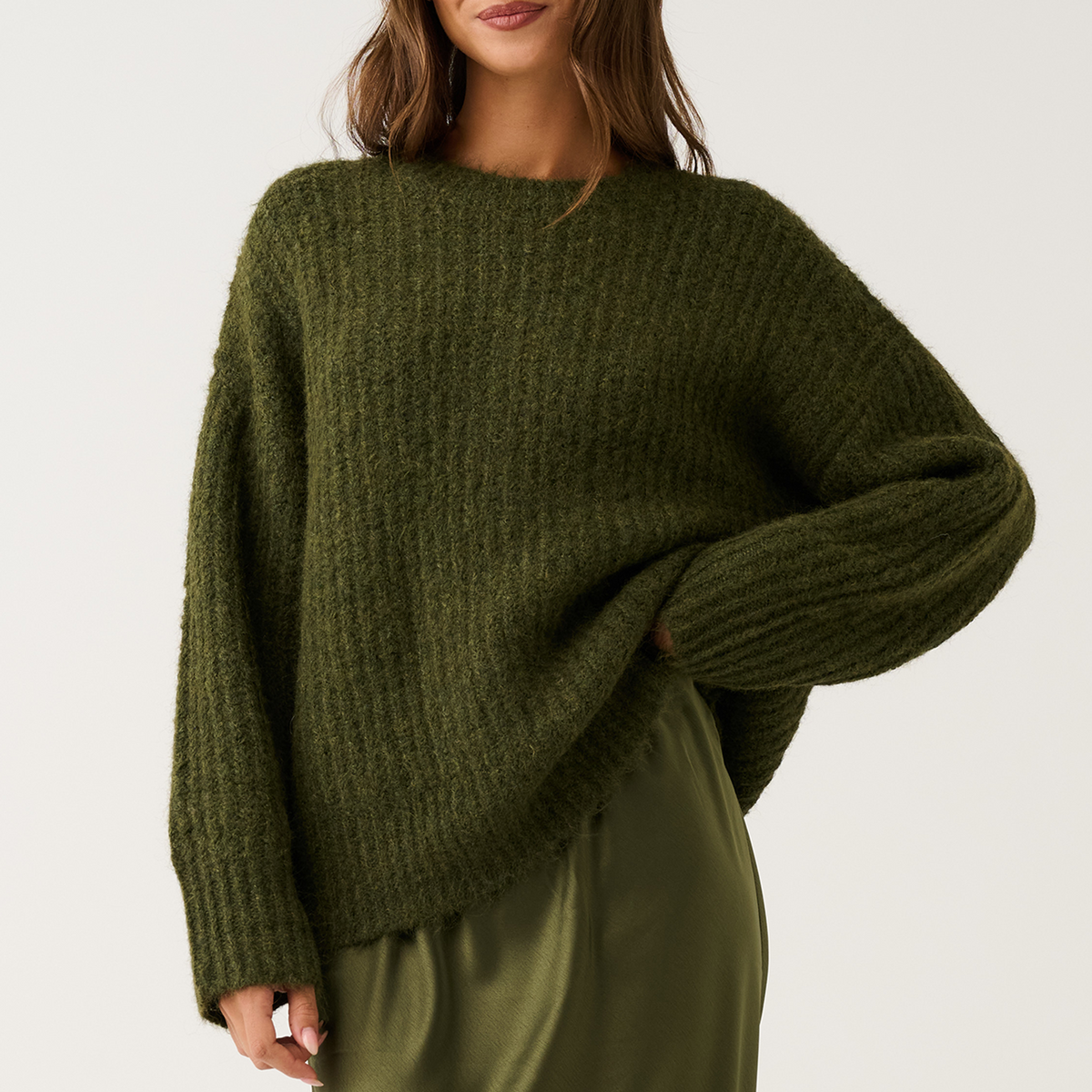 Three-quarter front view of an olive green oversized ribbed knit sweater with relaxed long sleeves and round neckline