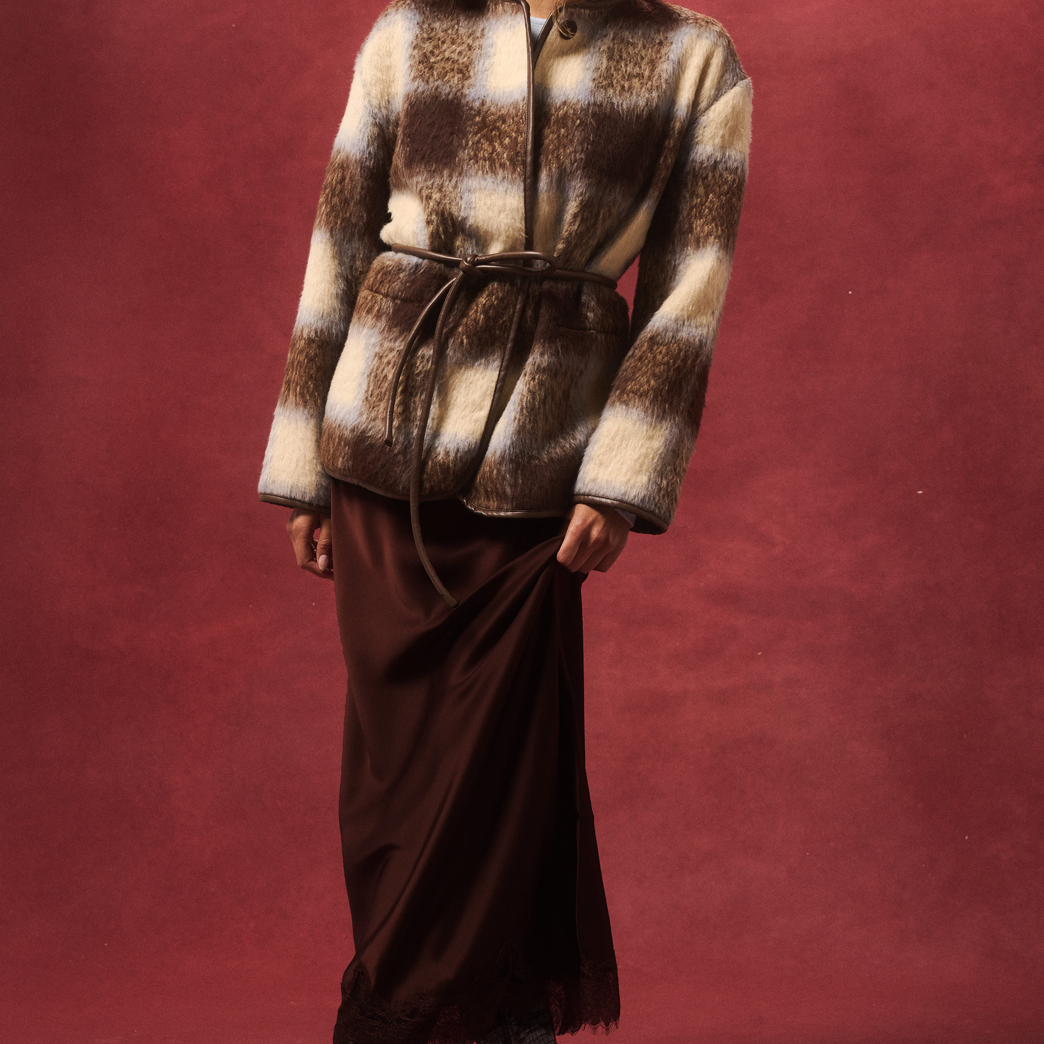 Front view of Luka Jacket showing check pattern faux fur texture with brown leather belt tie