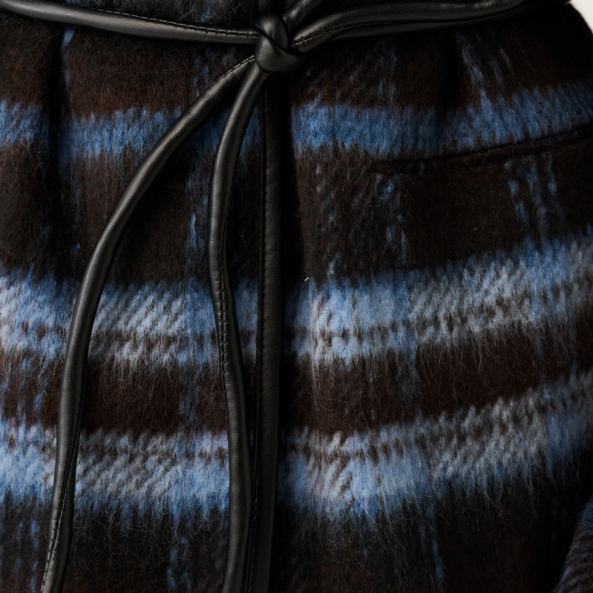 Detail shot of the black leather knot tie belt on a blue and brown check textured jacket