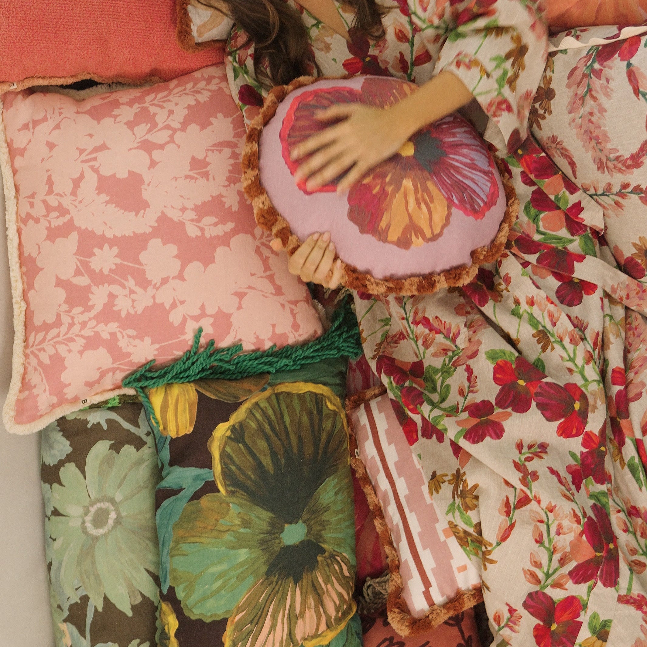 Model wearing Lupin Multi Linen Robe with floral pattern while relaxing in bed with decorative pillows
