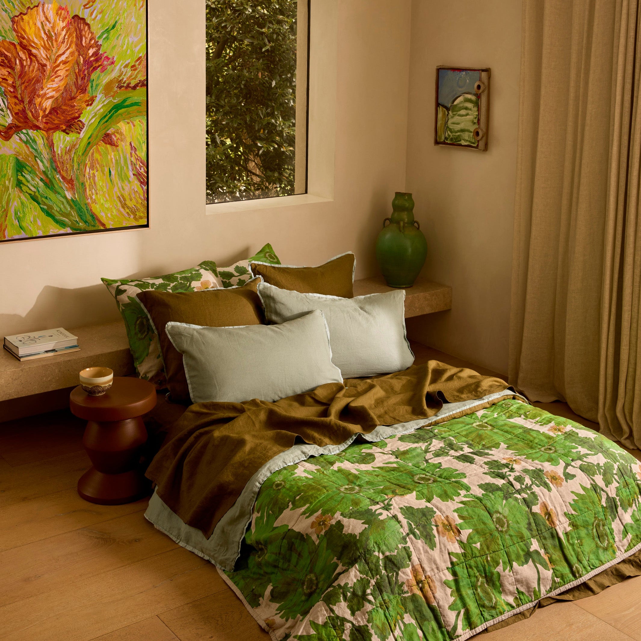 Lupin Multi & Marigold Leaf linen quilted throw draped on bed with green leaf and floral botanical print