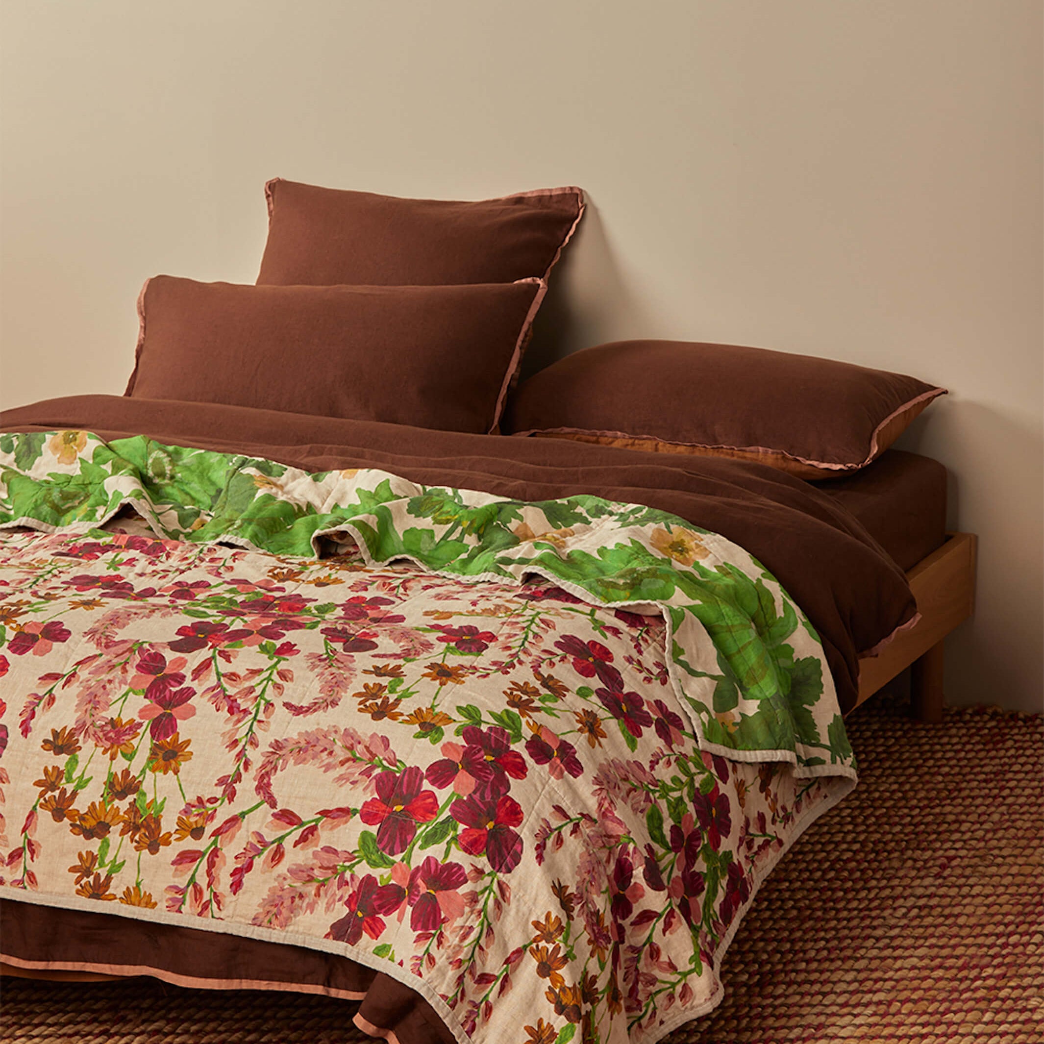 Side view of Lupin Multi linen quilted throw showing green leaf pattern and marigold floral reverse side