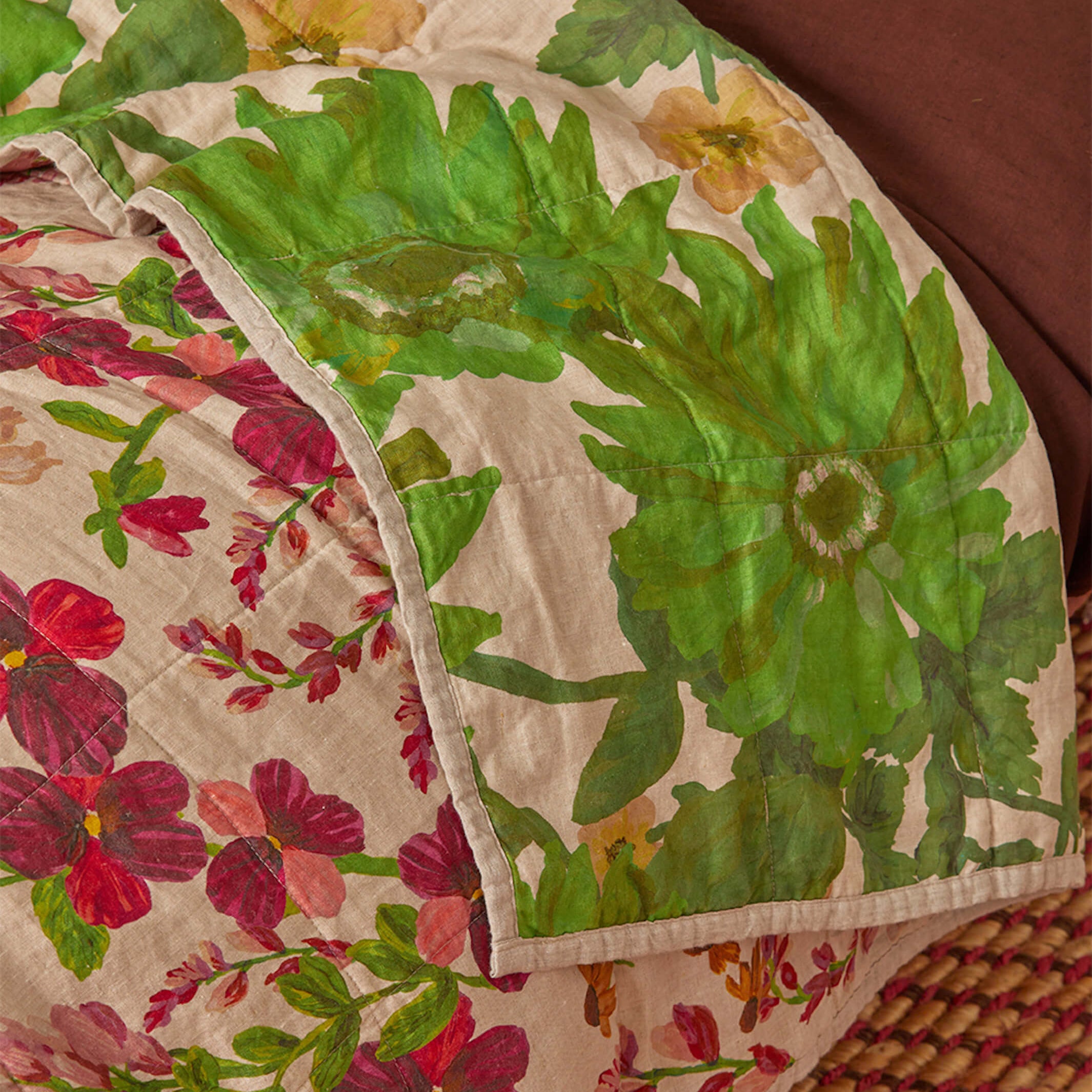 Close-up of Lupin Multi quilted throw showing large green leaf pattern and quilted linen texture detail