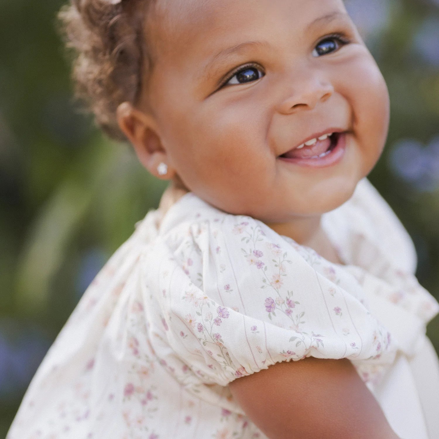 baby girl wearing Lyla Romper Floral Stripe by Noralee
