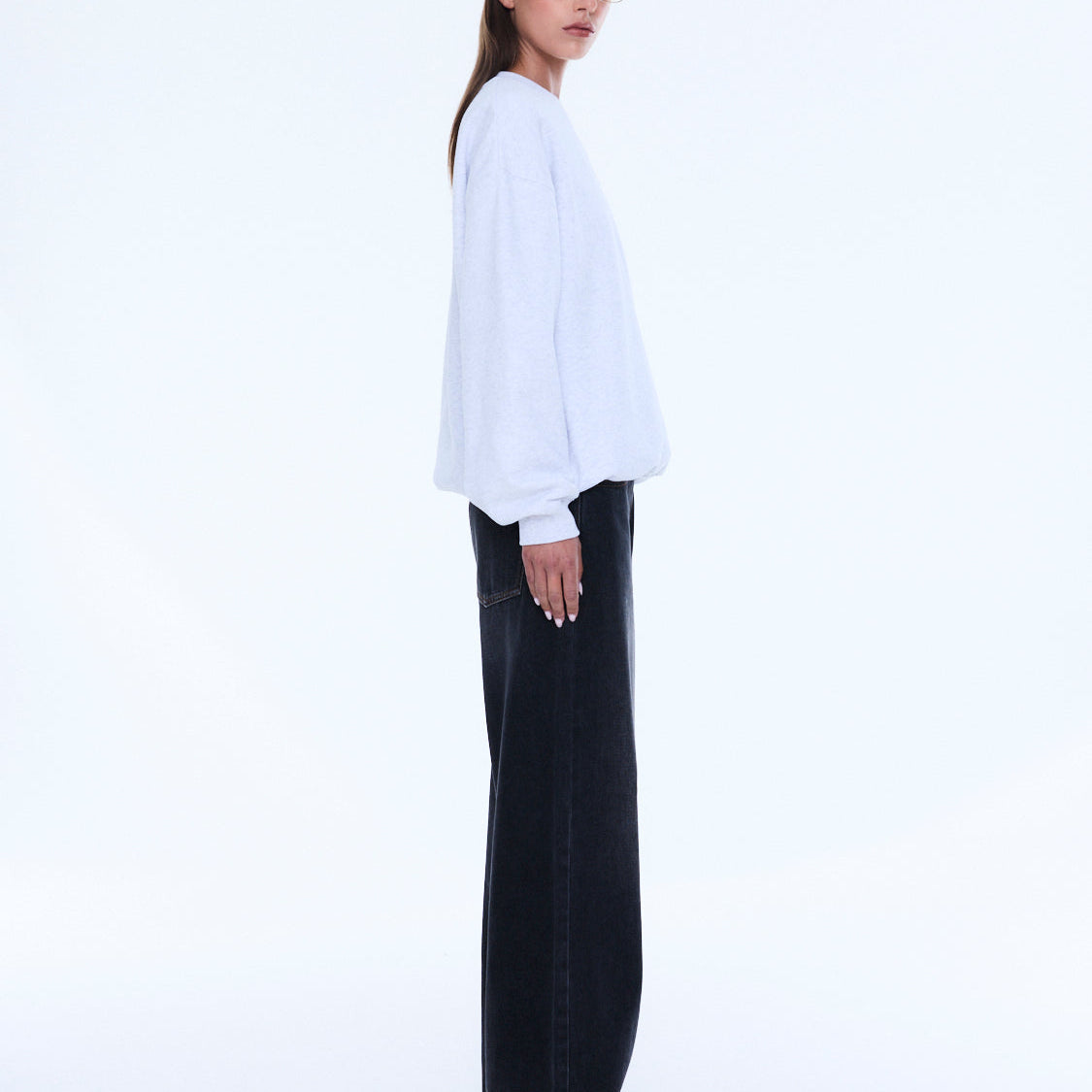 Side profile view of white Mila Oversized Sweater showing relaxed silhouette and long sleeves