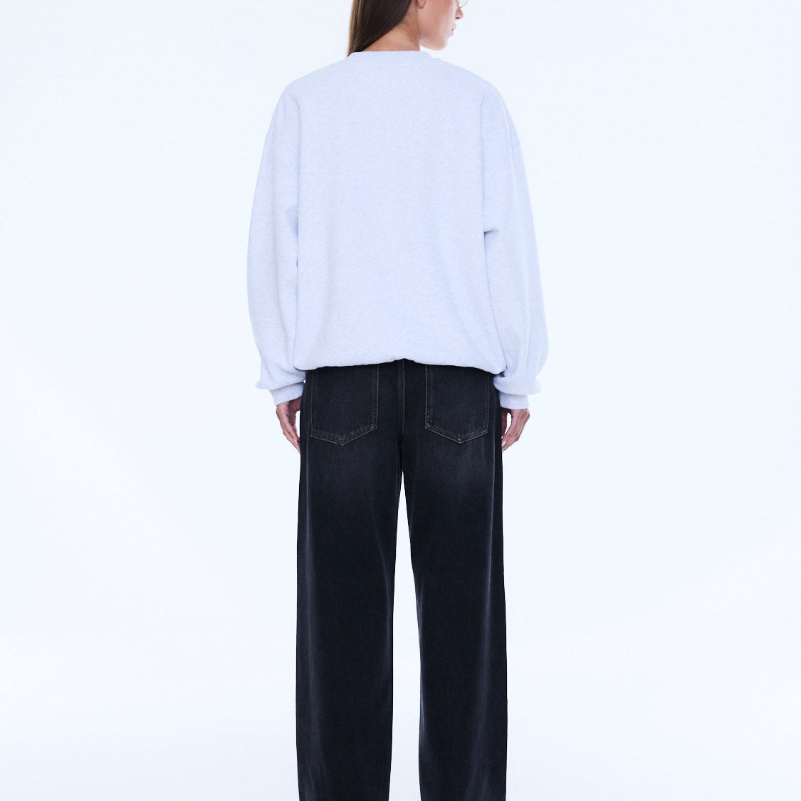 Back view of white oversized sweater showing plain back design and loose fit