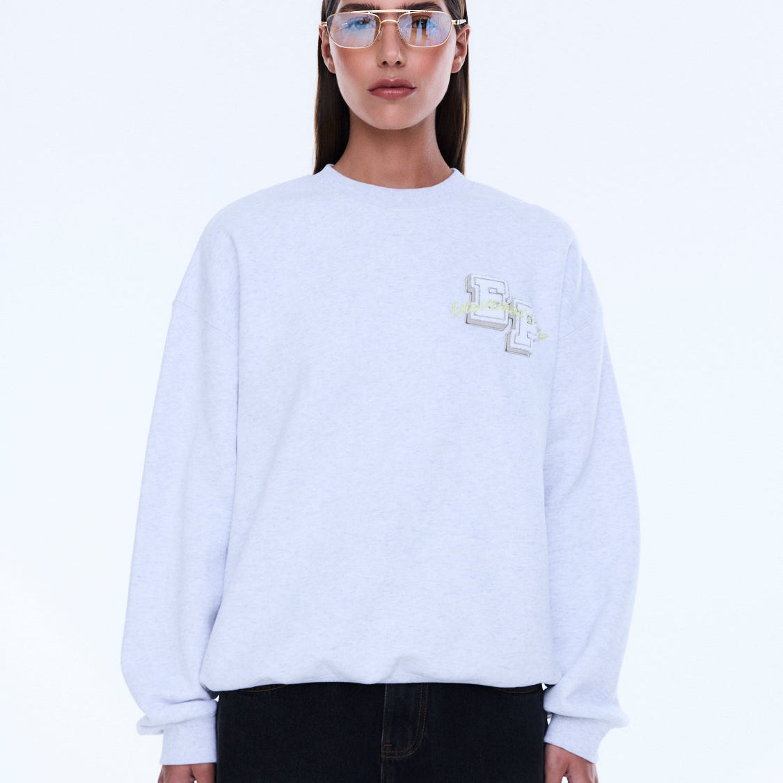 Front view of white Mila Oversized Sweater with embroidered logo and crew neckline