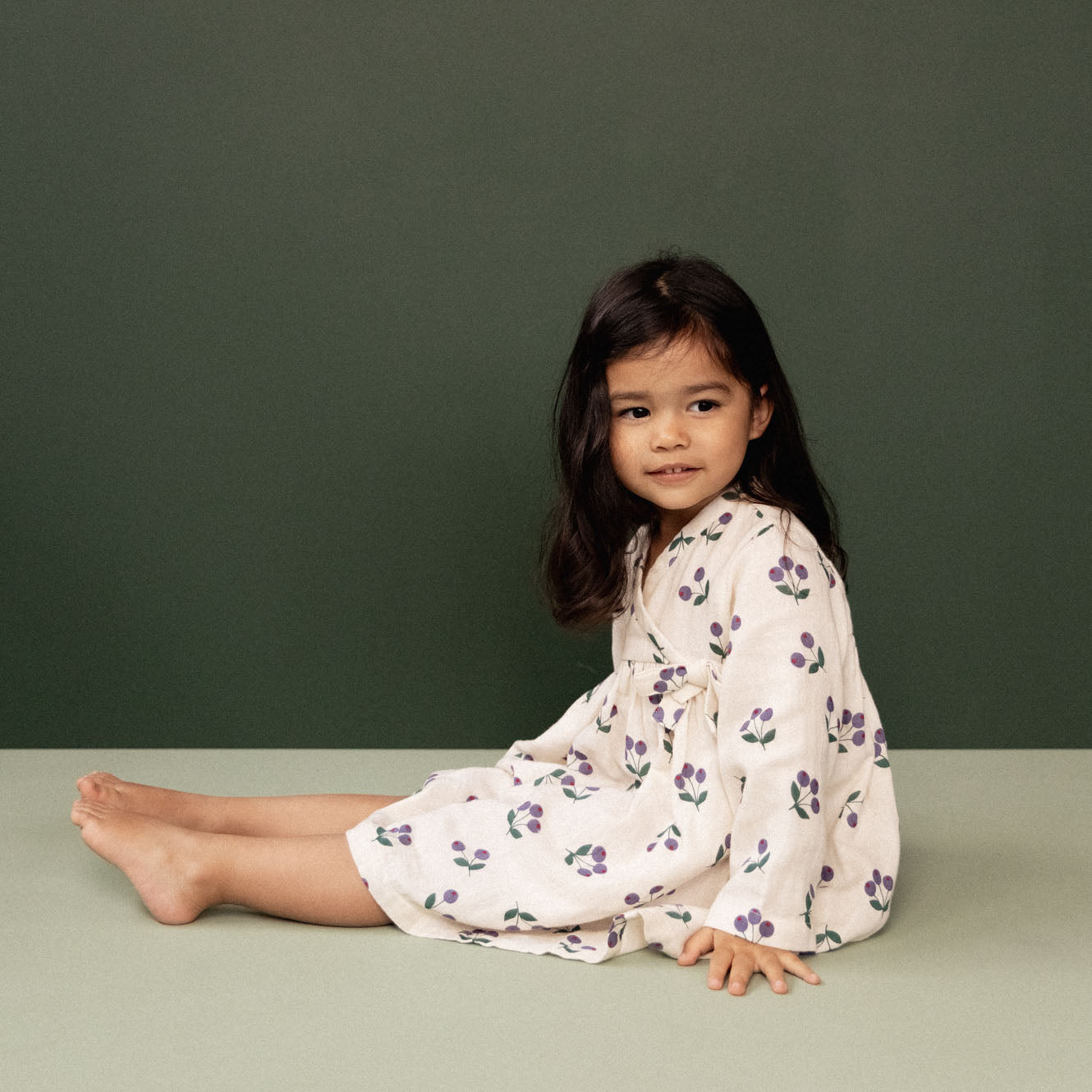 Side view of girl wearing the Mabel Dress - Winter Berry Natural Print | Nature Baby