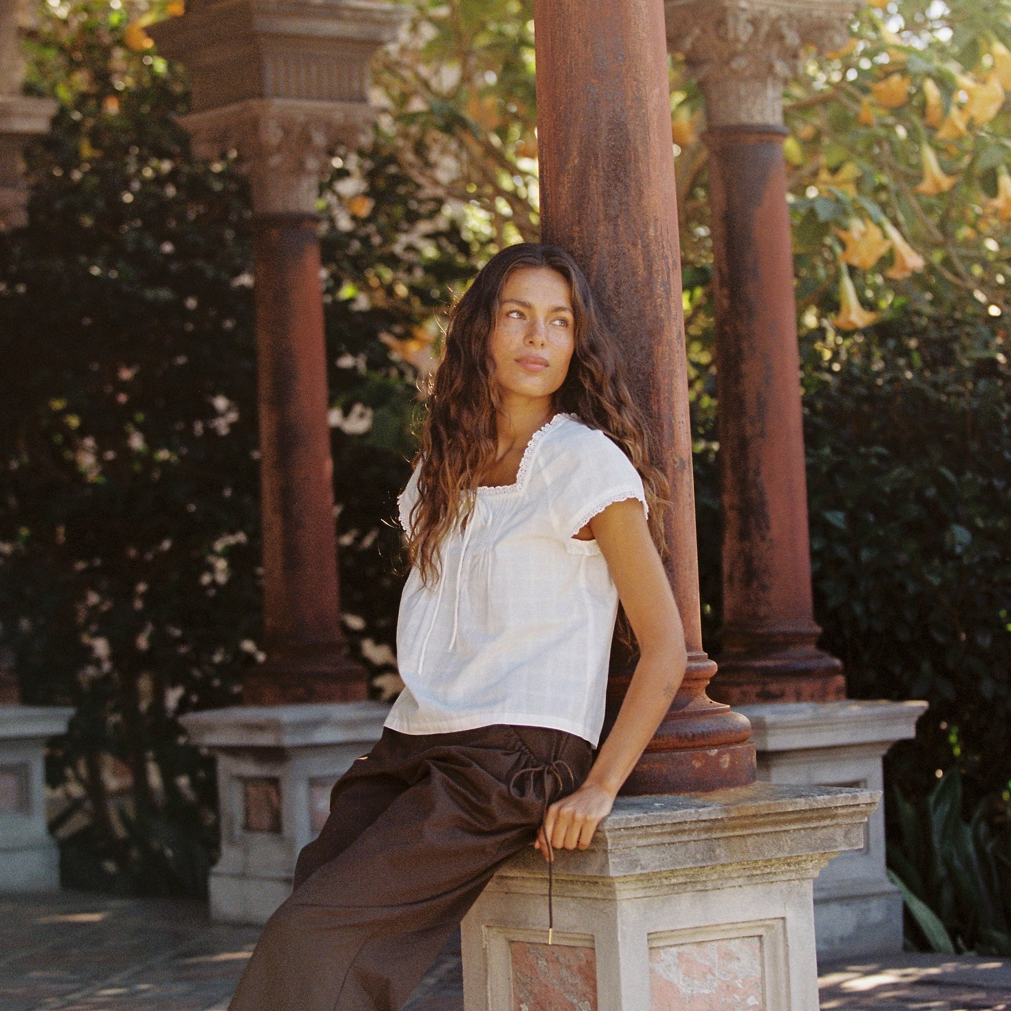 Lady wearing Juni Cotton pants with elasticated waistband and functional pockets in brown colour
