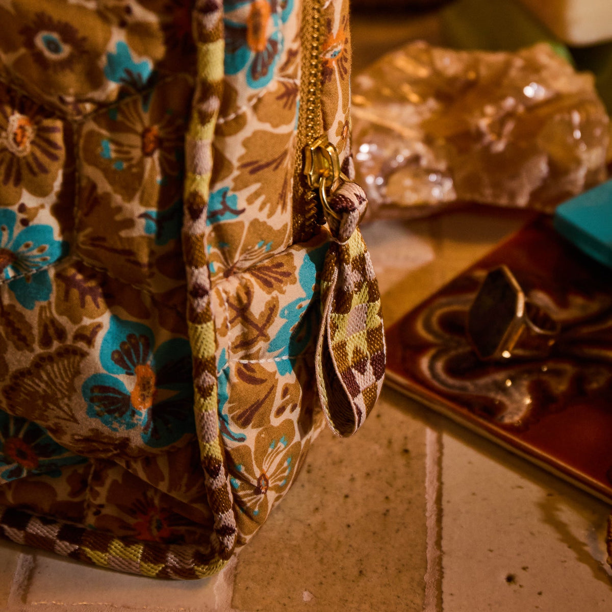 Close-up of Turquoise Magnolia Vanity Bag showing gold zipper pull and quilted floral fabric detail
