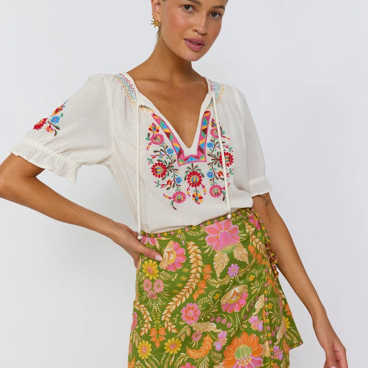 Close up lace-up hip accent with resin beads on Maison mini skirt guava print