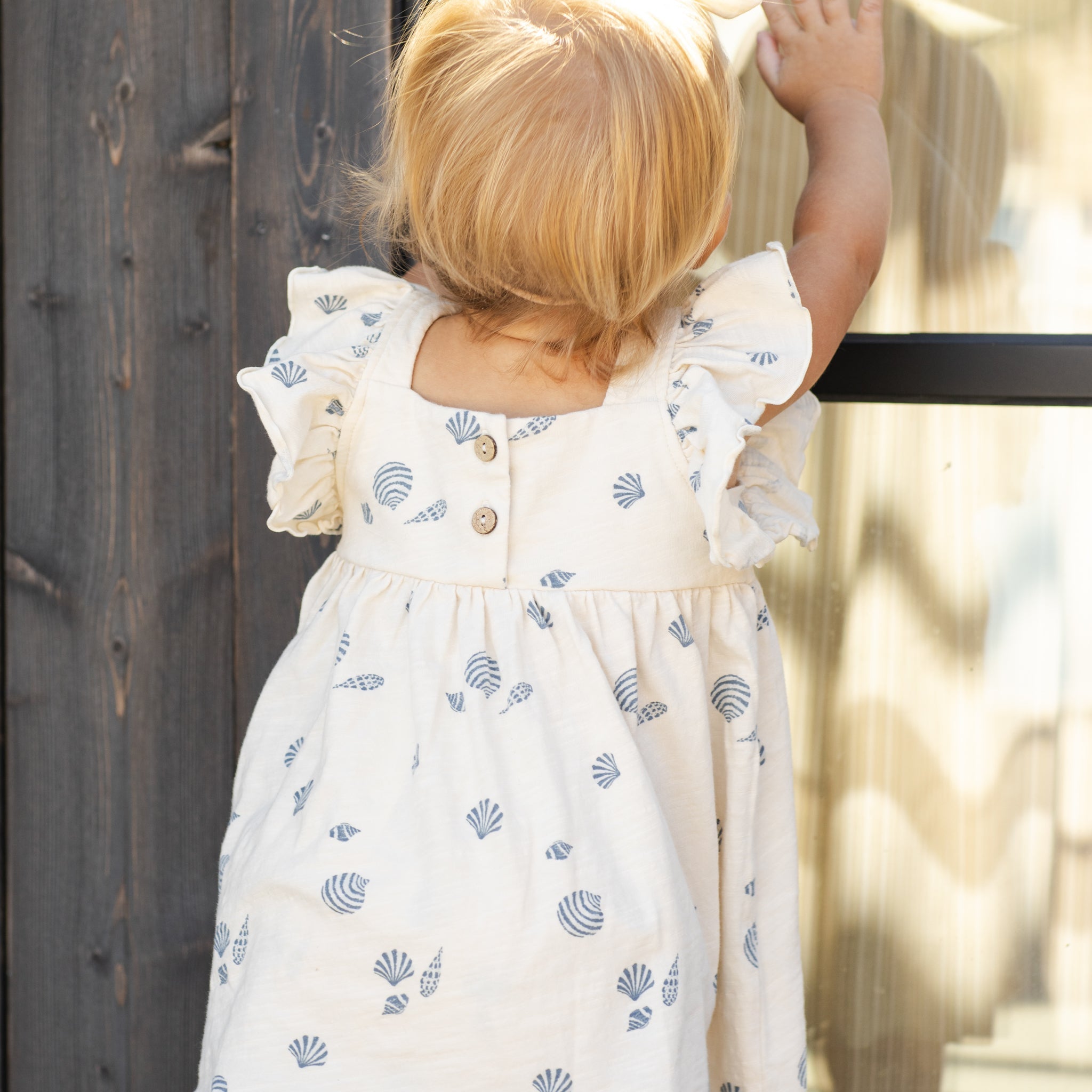 Back view of girl wearing Mariposa Seashell Dress | Rylee + Cru
