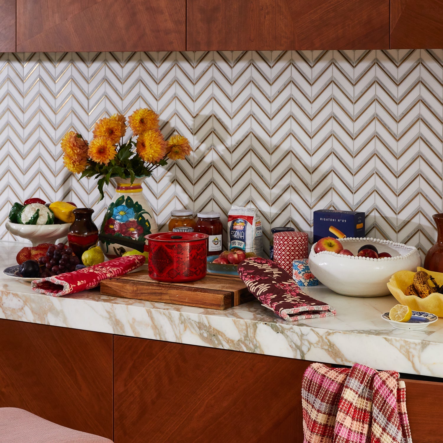 Full kitchen scene showing Marta Oven Mitts with marble countertops and contemporary kitchen accessories