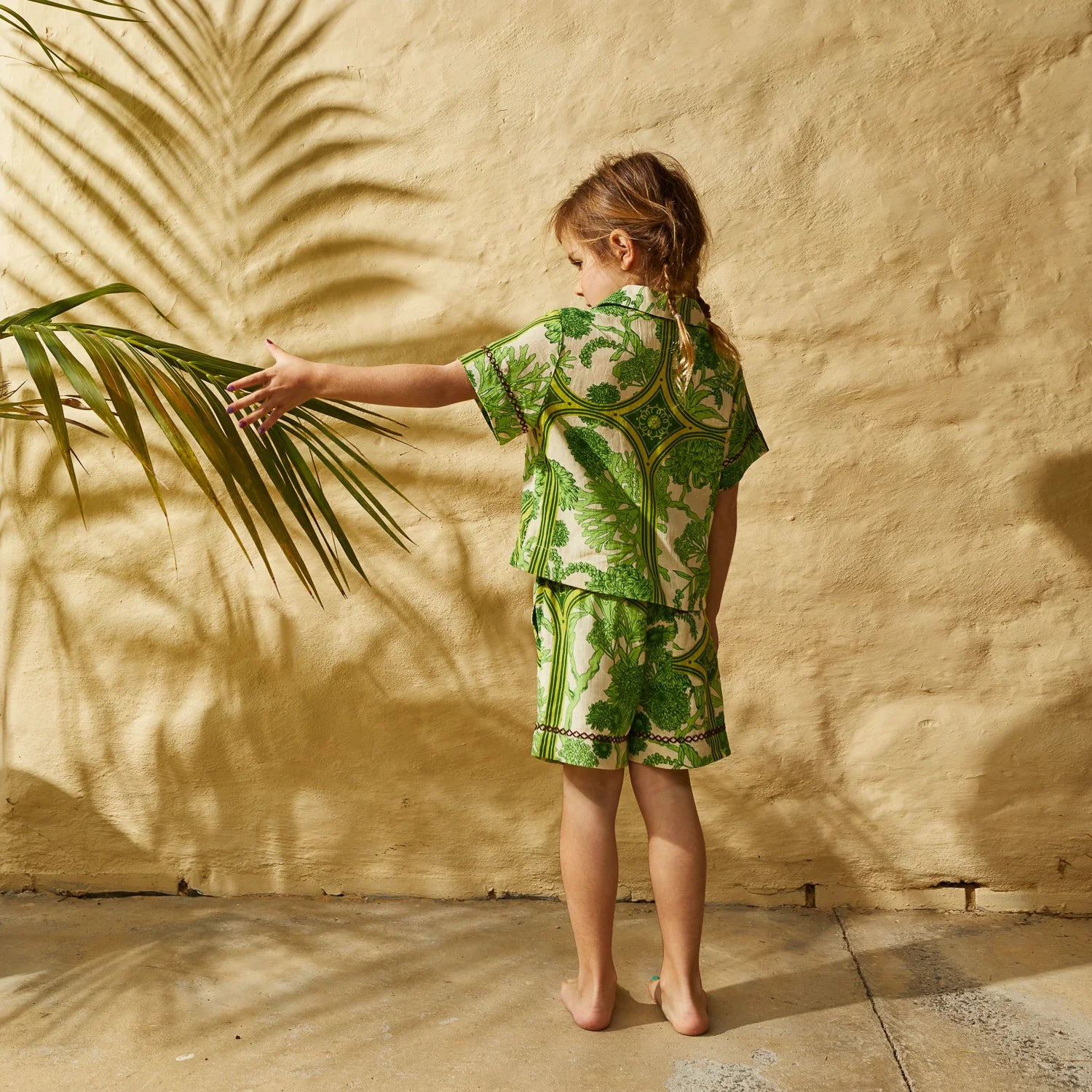 girl wearing retro floral print matching set in green - Naia Kids Resort Set by Sage & Clare