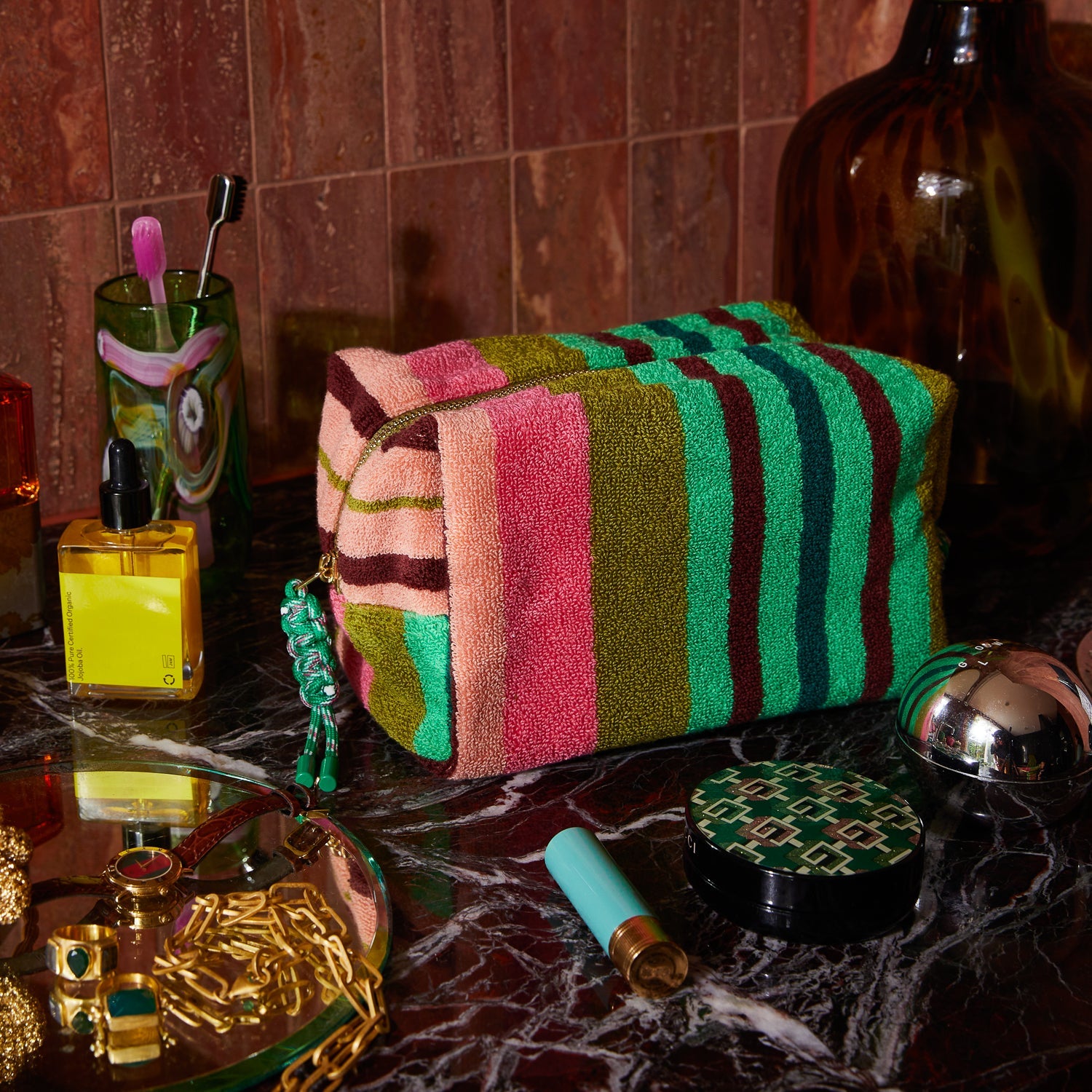 Sage & Clare Nicolette Terry Pouch styled on marble bathroom counter with luxury skincare and beauty products