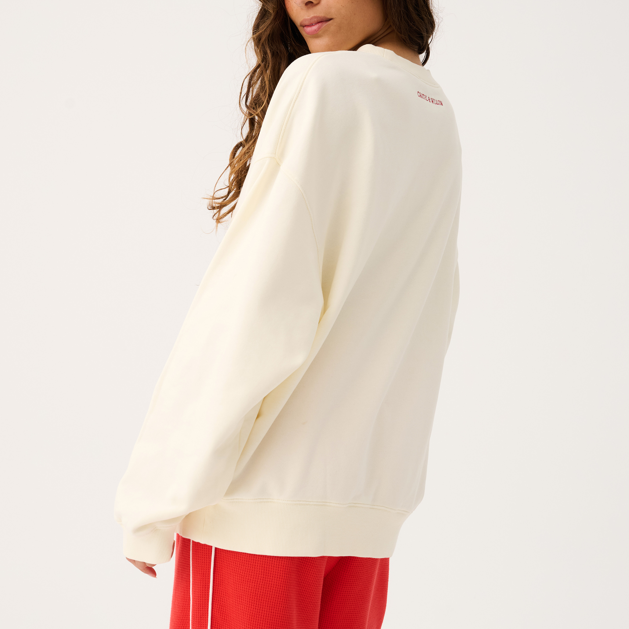 Back view of Nina Sweater in cream showing relaxed fit and long sleeves with ribbed cuffs