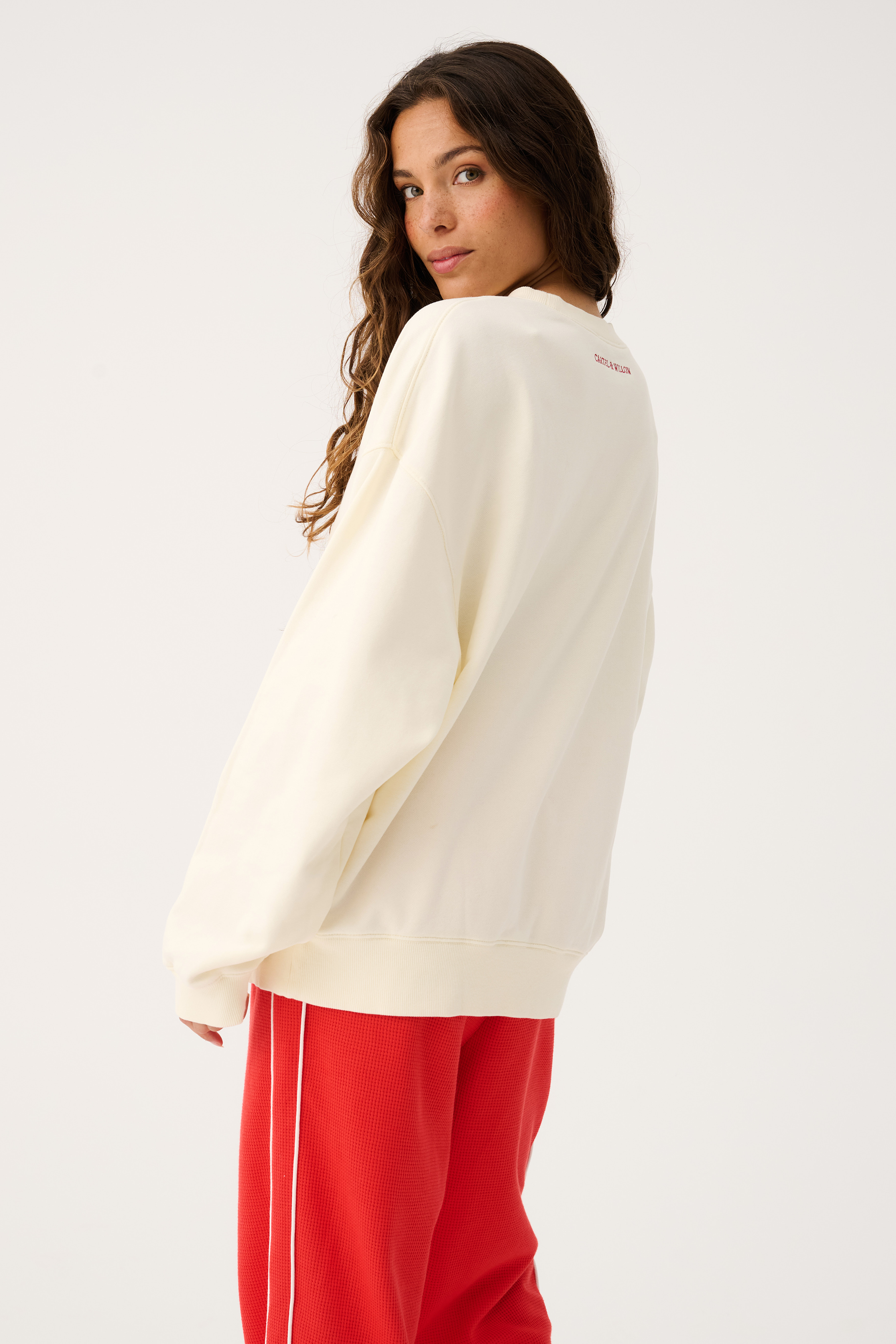 Back view of Nina Sweater in cream showing relaxed fit and long sleeves with ribbed cuffs