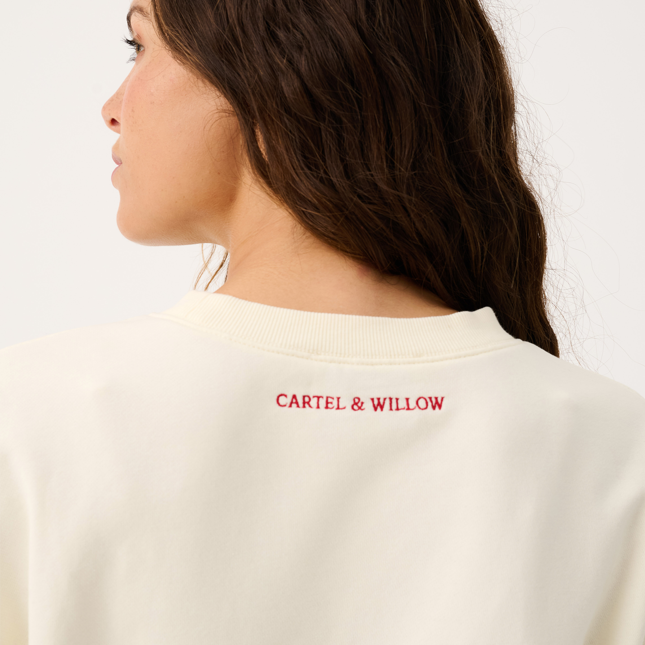Close-up back detail of Nina Sweater showing red Cartel & Willow logo print on cream fabric