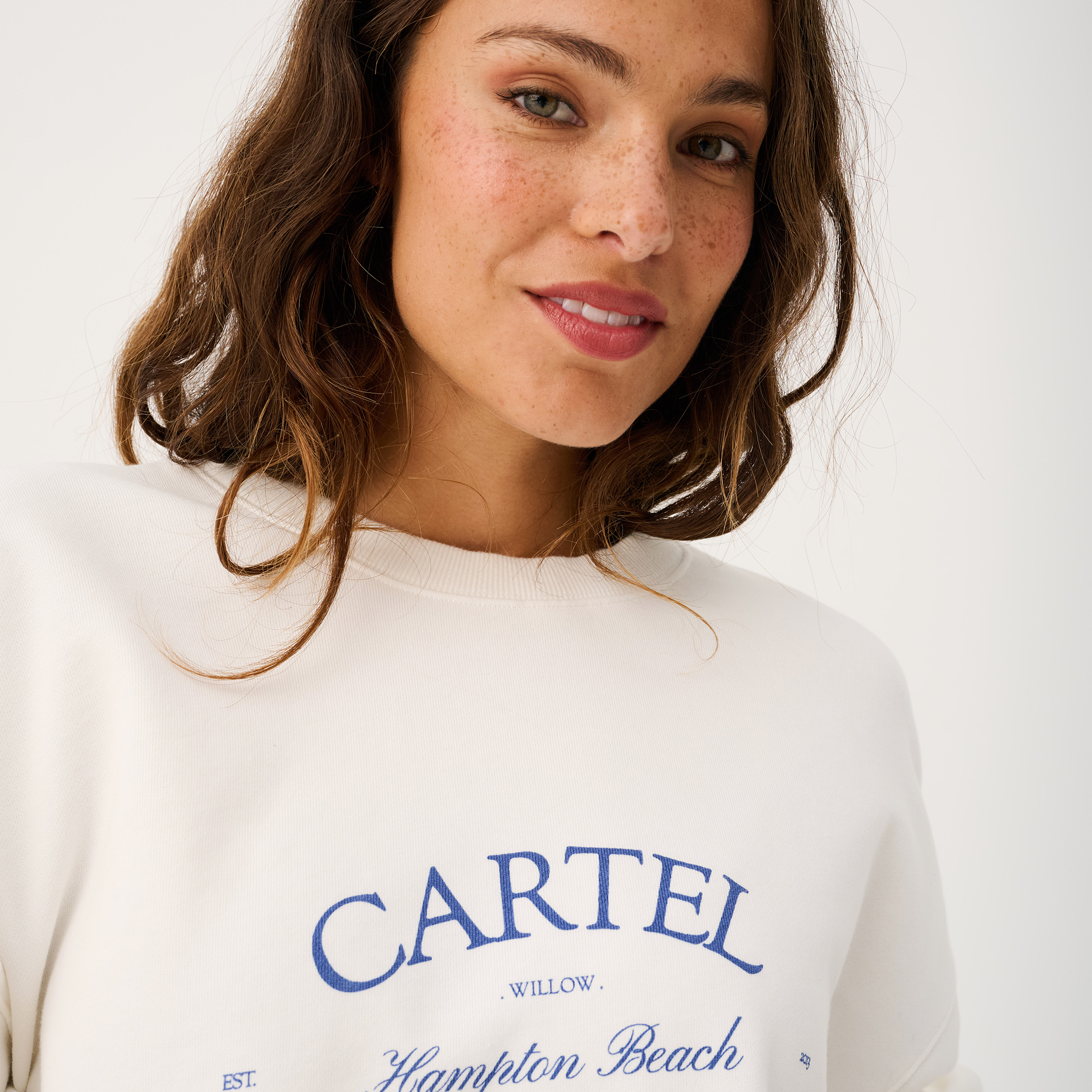 Front view of white Nina Sweater with blue Hampton Beach text and crew neckline