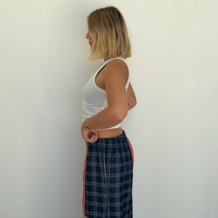 Side profile view showing Olive Checkerboard Pant wide leg silhouette and colorblock construction