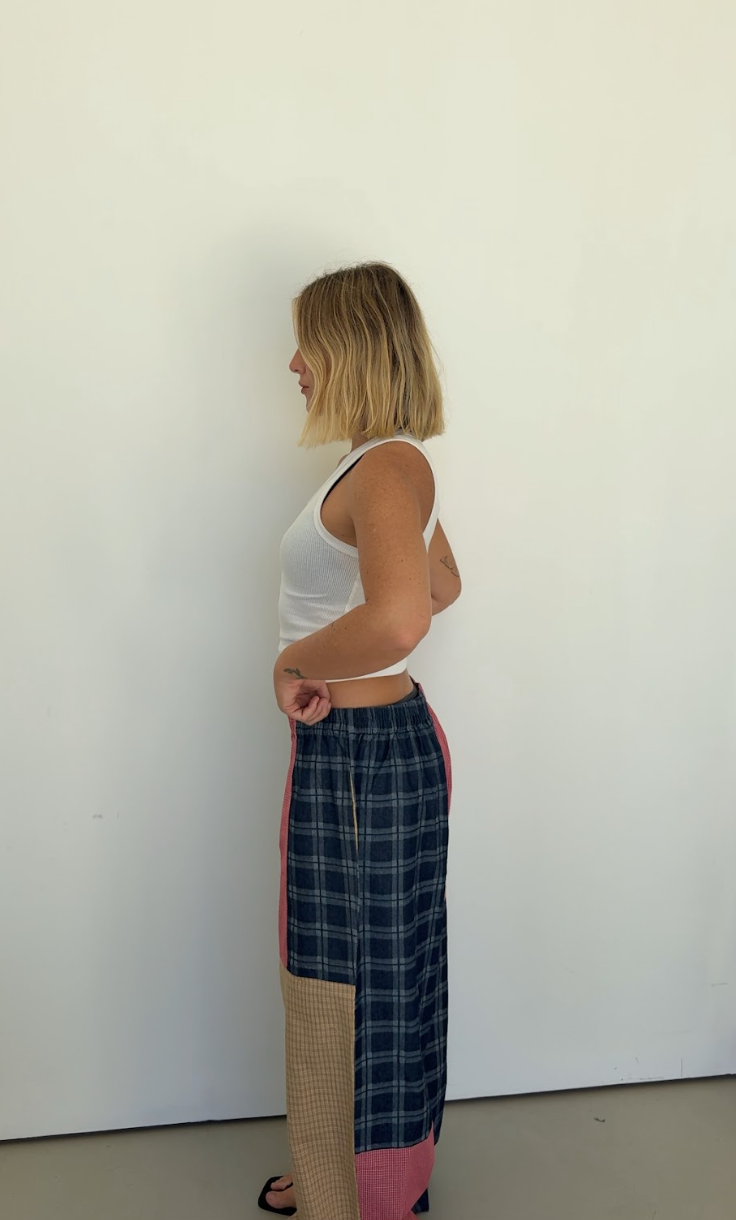 Side profile view showing Olive Checkerboard Pant wide leg silhouette and colorblock construction