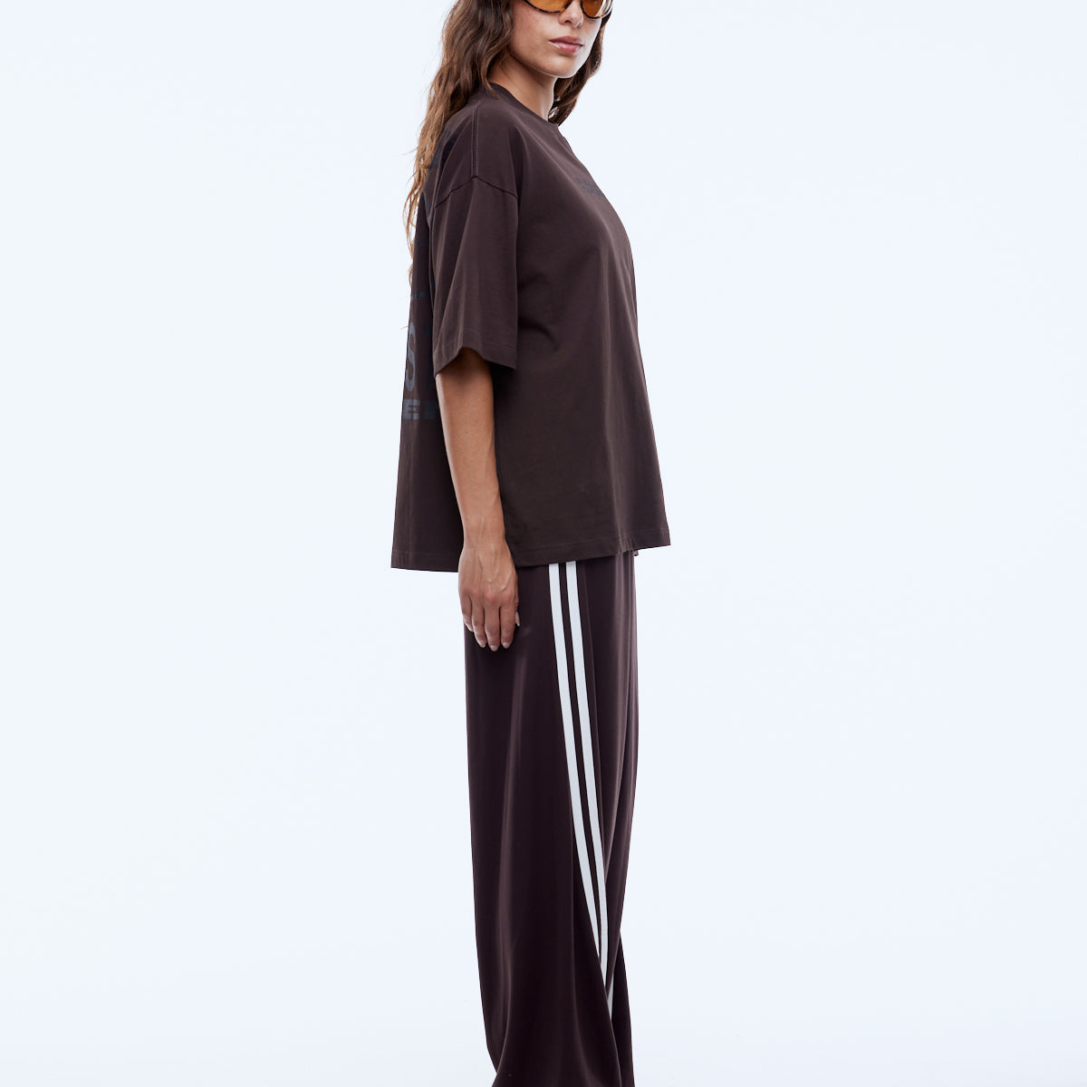 Side profile view of oversized brown Sport Star Tee showing dropped shoulder and loose silhouette