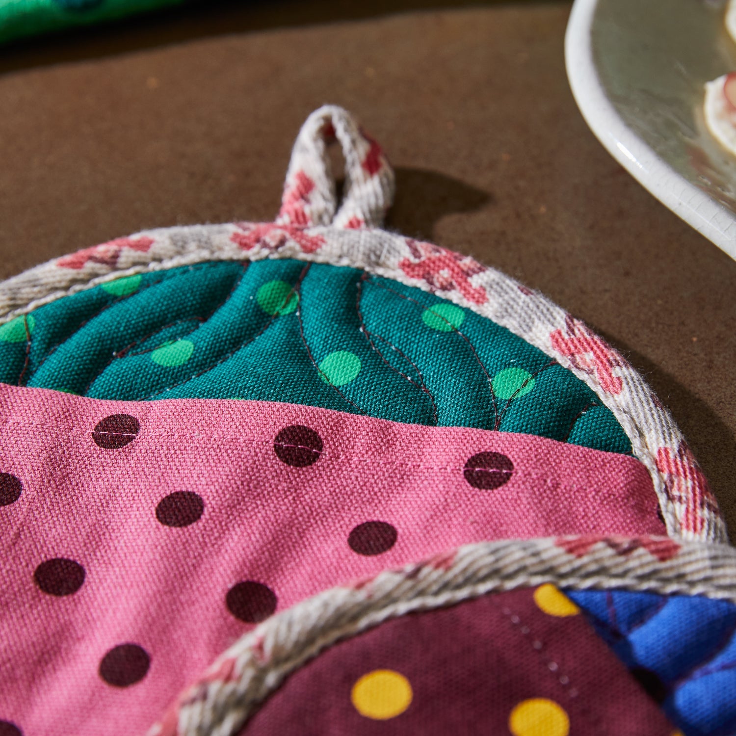 Close-up detail of polka dot pattern and woven rope trim on Paige pot holder set colorful fabric