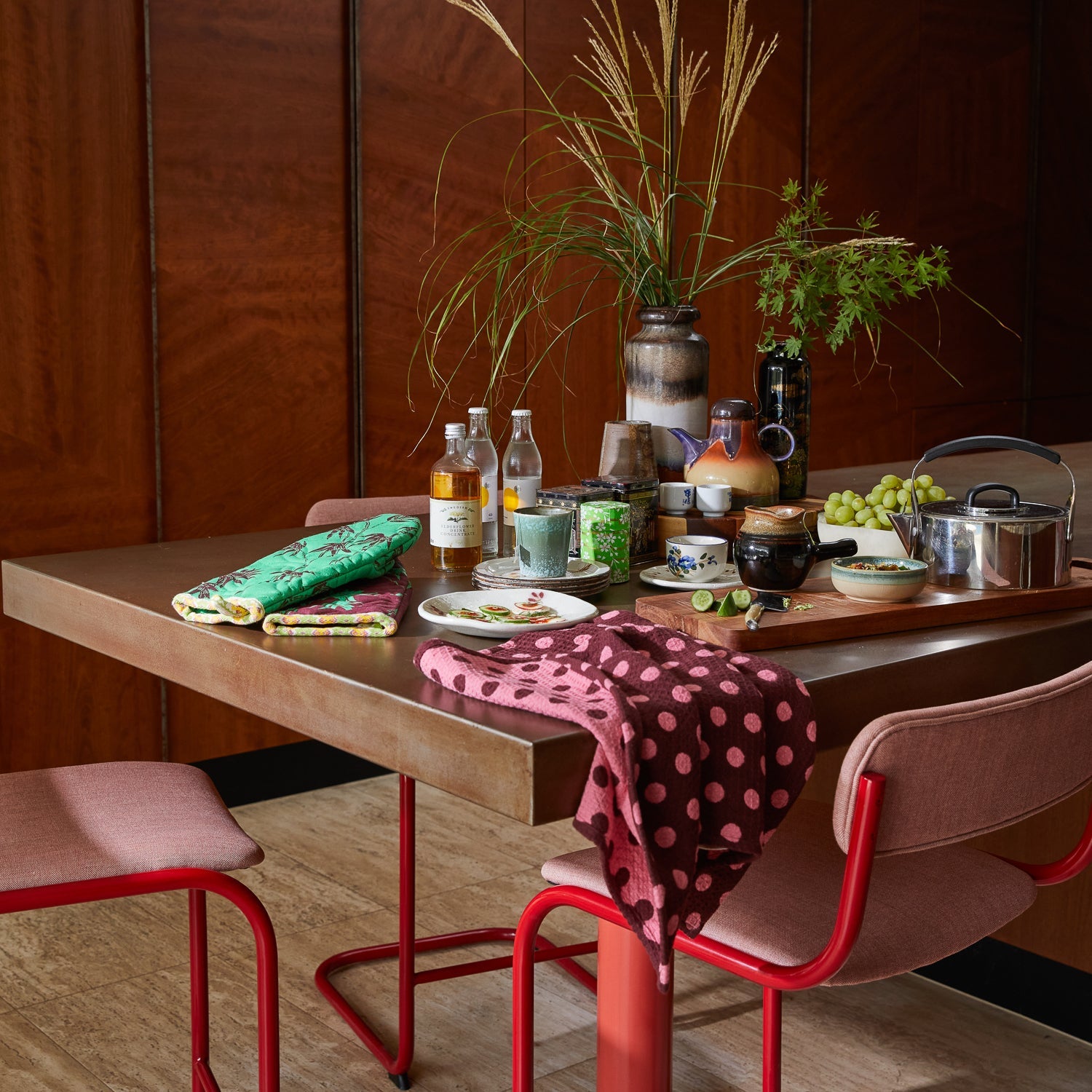 Sage & Clare Paige tea towels styled on dining table with kitchen accessories and colorful spot design