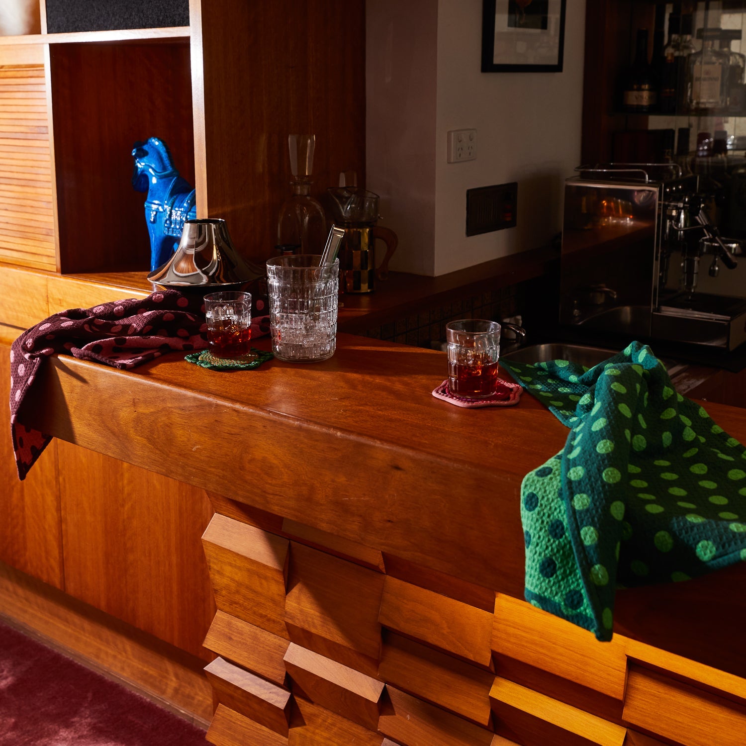 Kitchen styling with Paige Tea Towels in Rosewood on wooden counter beside glassware and home bar setup