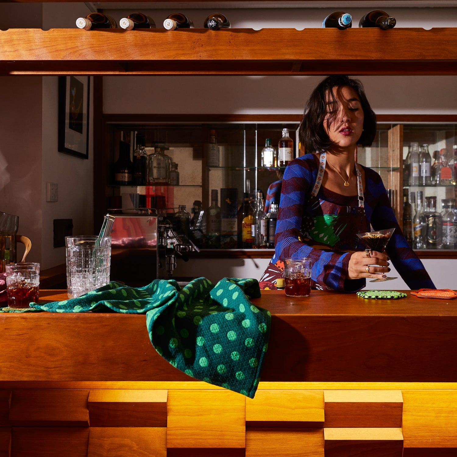 Model using Paige Tea Towel Verdant in modern kitchen bar setting with waffle weave texture