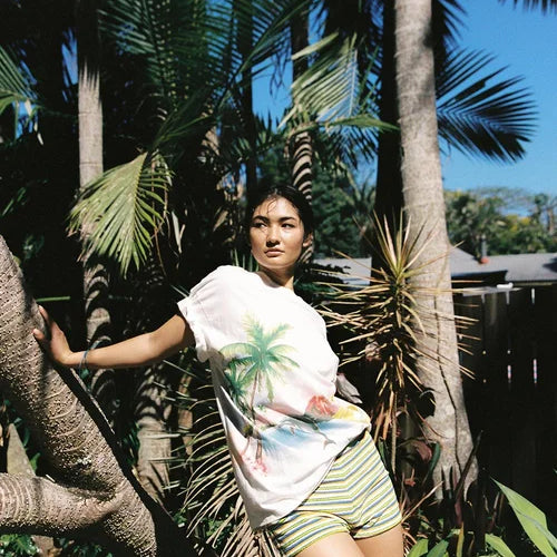 model wearing Paradise T-Shirt by Sea Street - white cotton tshirt with palm tree and dolphin
