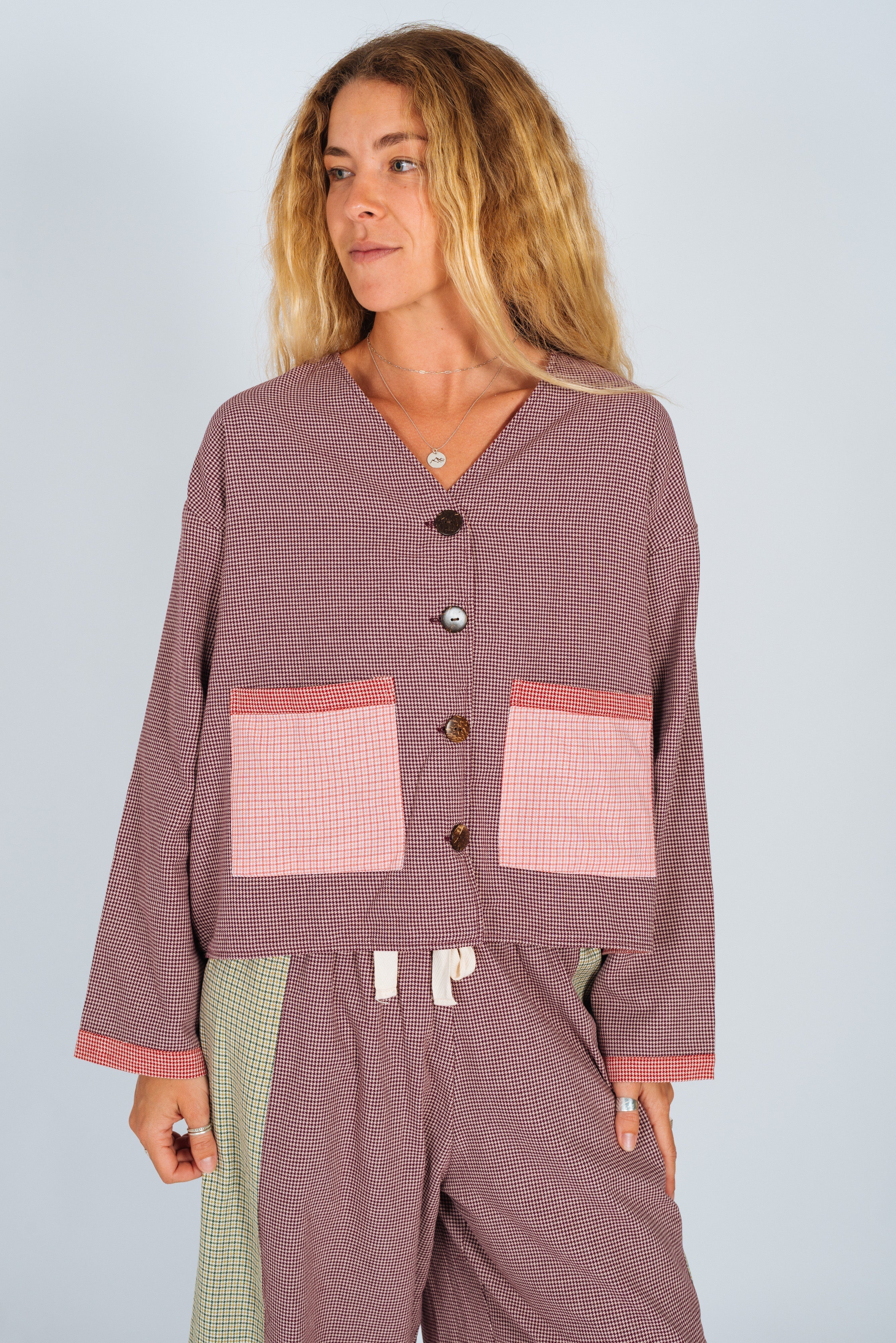 Studio shot of patchwork over shirt showing houndstooth pattern with contrasting fabric panels and pockets