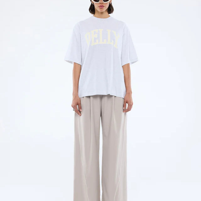 Model wearing Pelly Collegiate Tee White Marle by Ena Pelly - white tshirt with cream yellow text "Pelly"