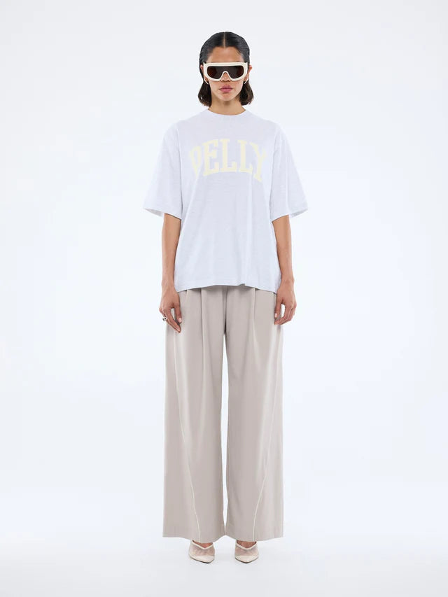Model wearing Pelly Collegiate Tee White Marle by Ena Pelly - white tshirt with cream yellow text "Pelly"