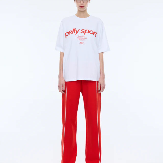model wearing white tshirts with red writing "Pelly Sport" across the front