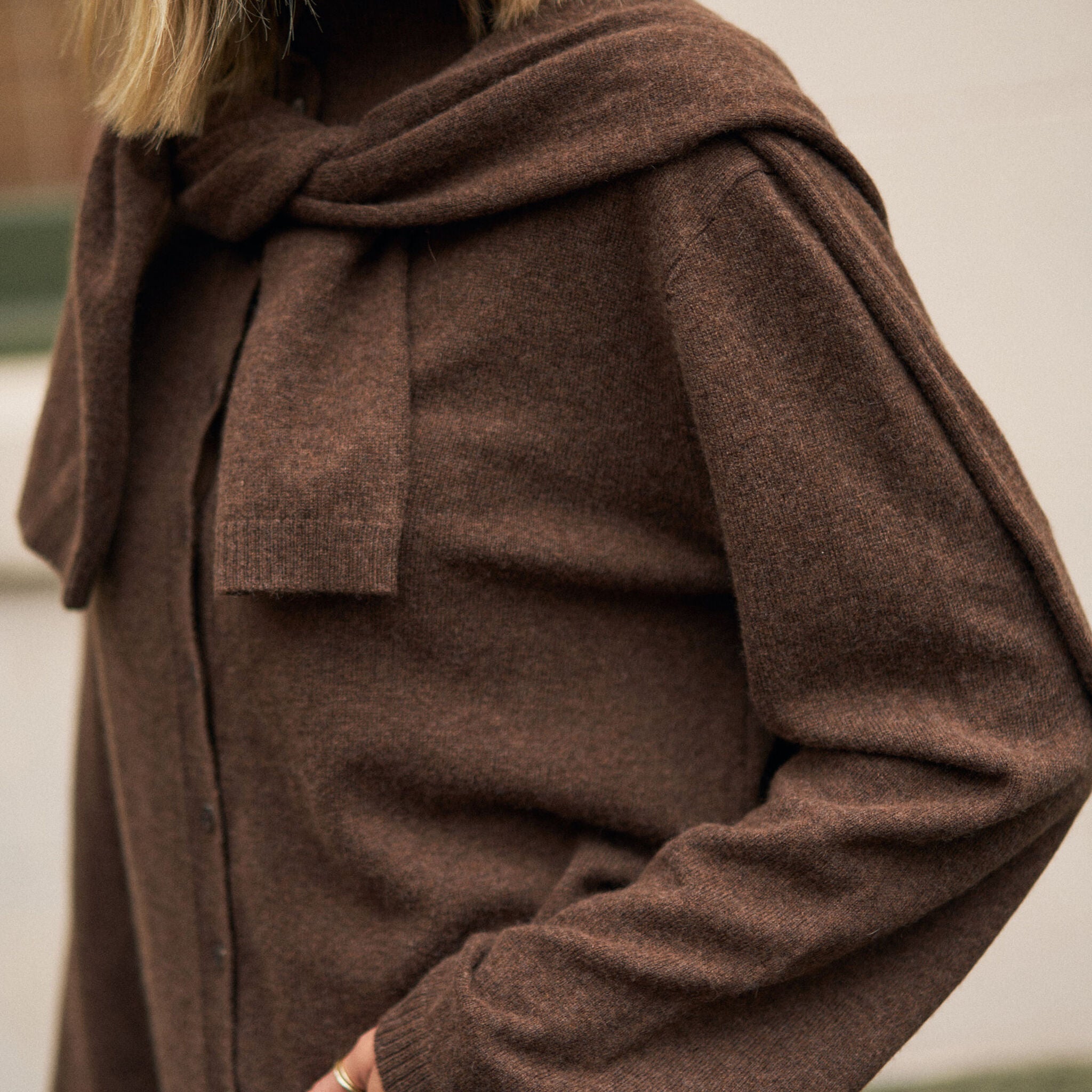Close-up detail of chocolate marle knit cardigan showing draped collar and button closure construction