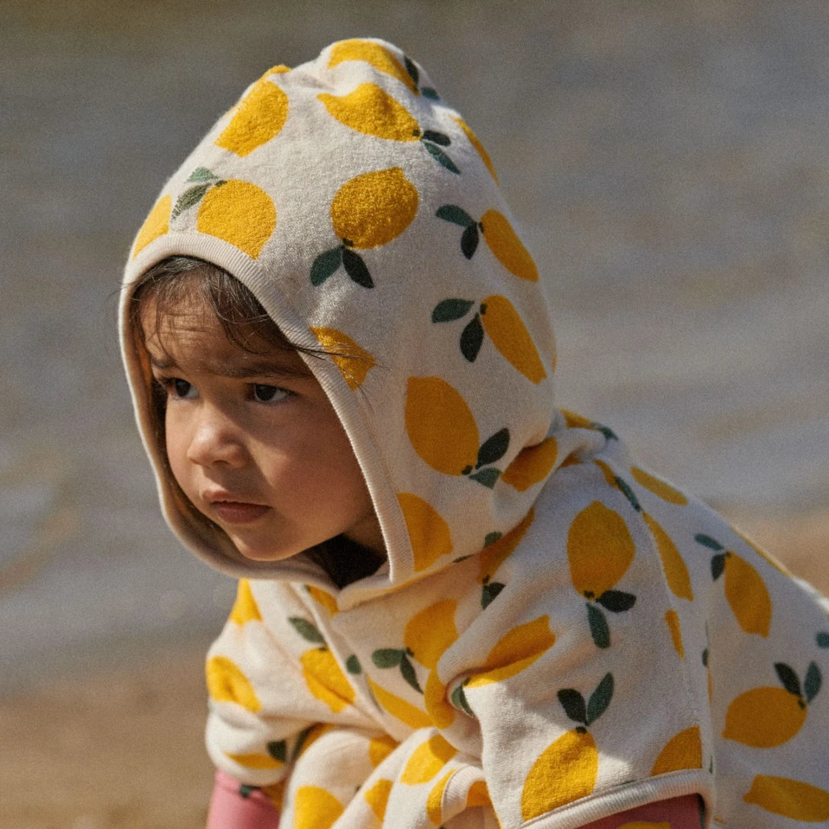 child wearing a swim hooded towel made from terry towelling - Poncho Towel - Lemon Print Terry by Nature Baby